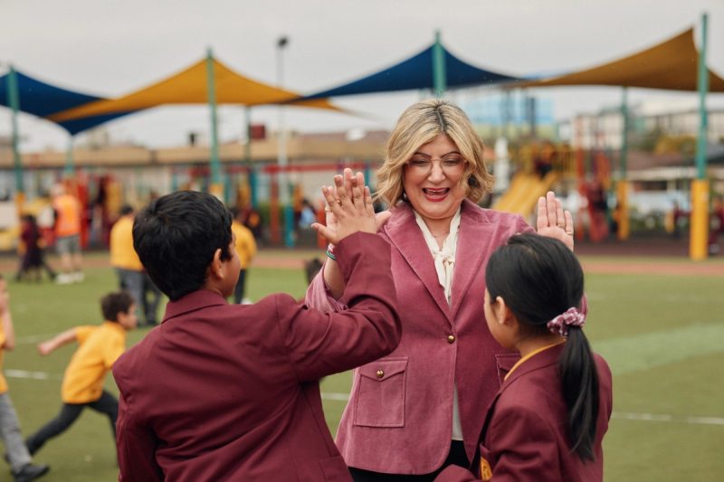 Natalie sharing high fives with students at a local school