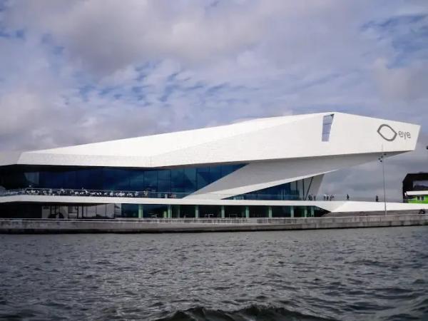 Le bâtiment blanc anguleux d'EYE, le Musée du Film d'Amsterdam, avec son logo, vu depuis l'eau de l'IJ
