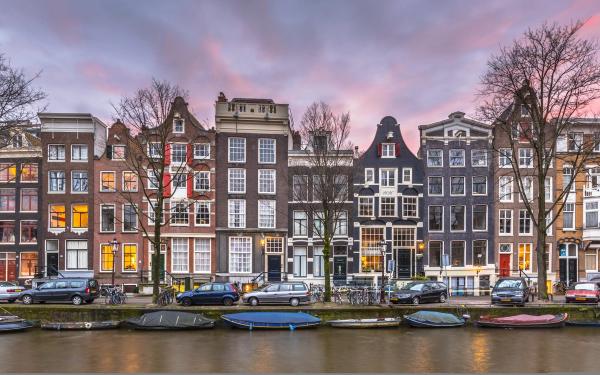 Maisons de canal du Brouwersgracht dans le Jordaan à Amsterdam au crépuscule, avec les barques amarrées et les vélos le long du quai © amsterdam.net