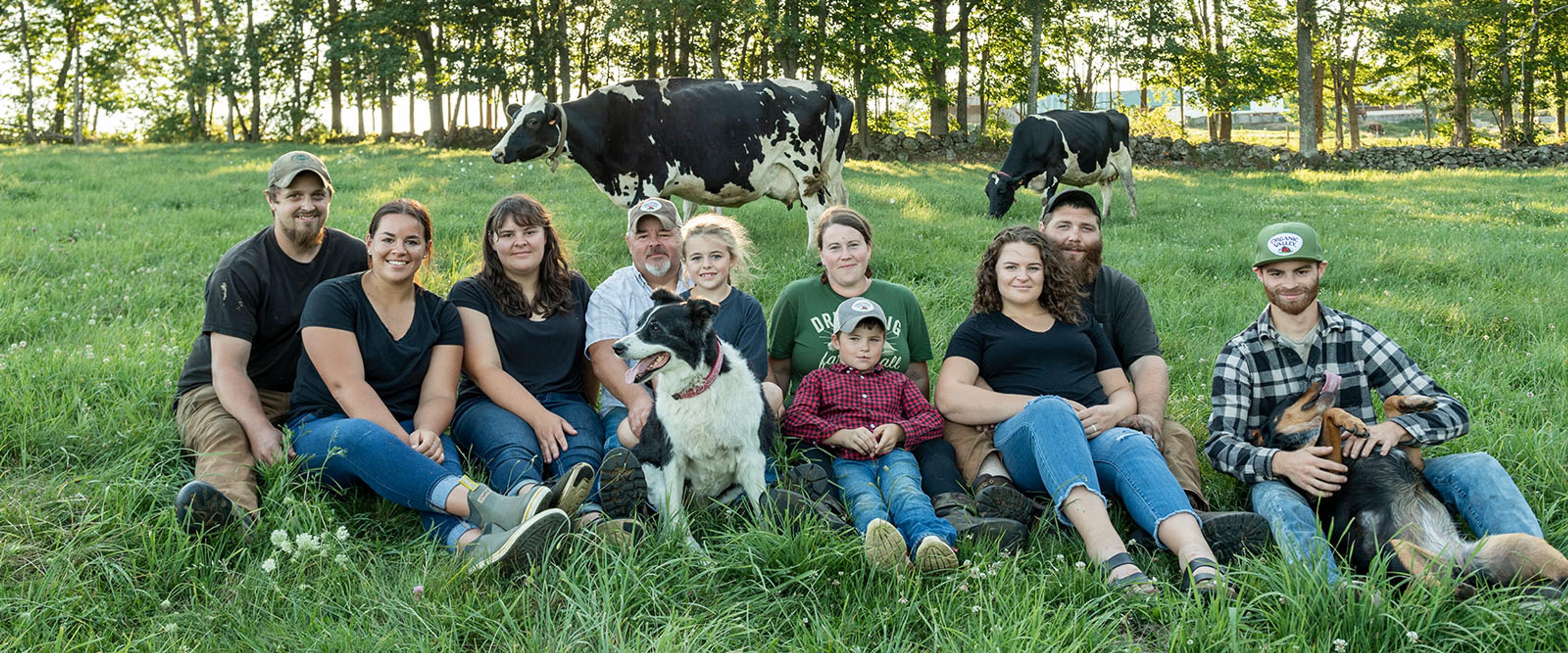 Mehuren family sits with cows in the background.
