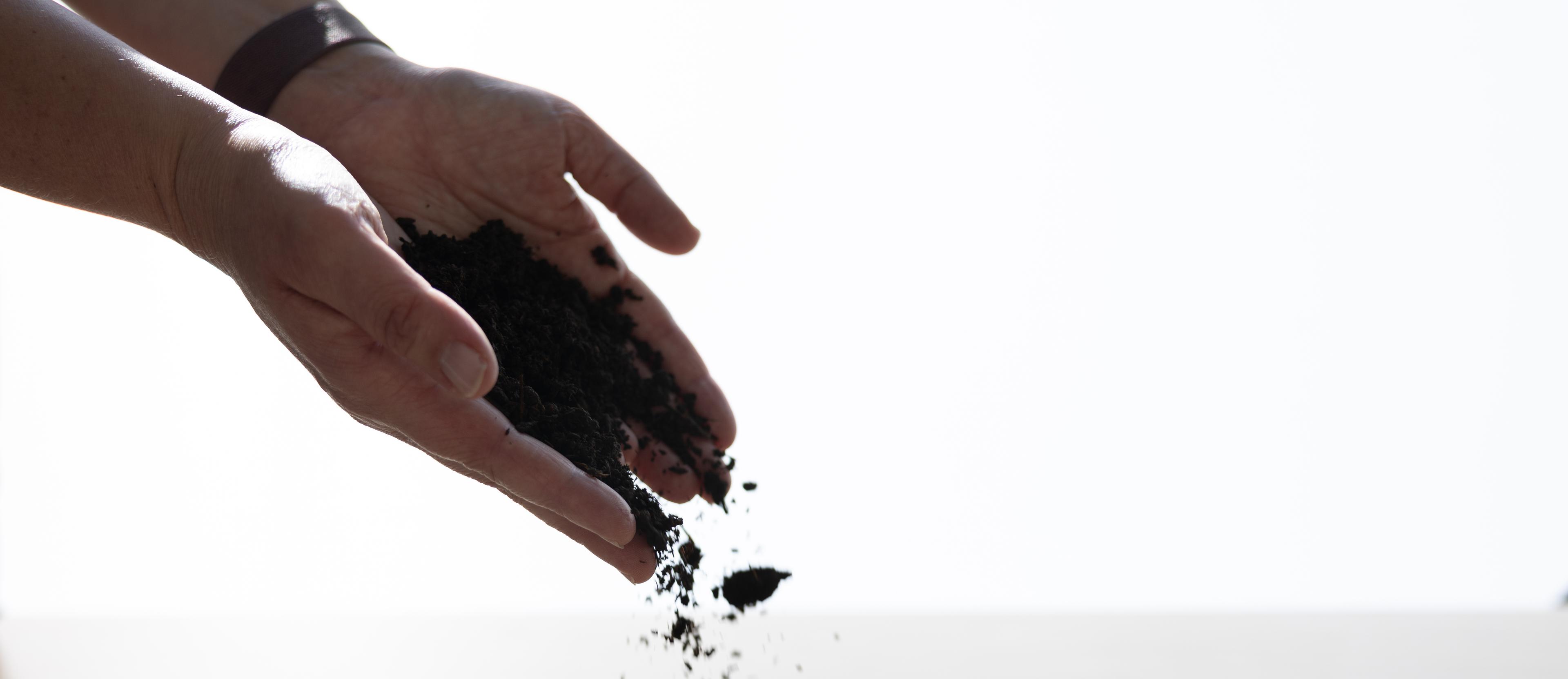 Soil falls out of a woman’s hands.