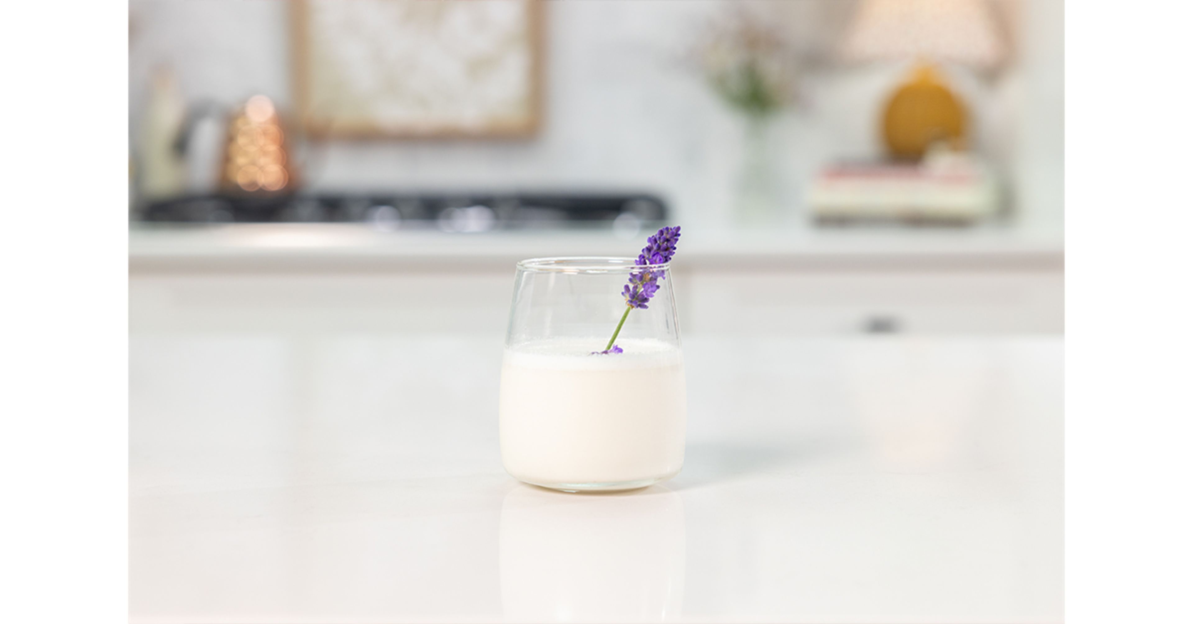 Honey Lavender Milk on a counter with a cutting of real lavender as garnish.