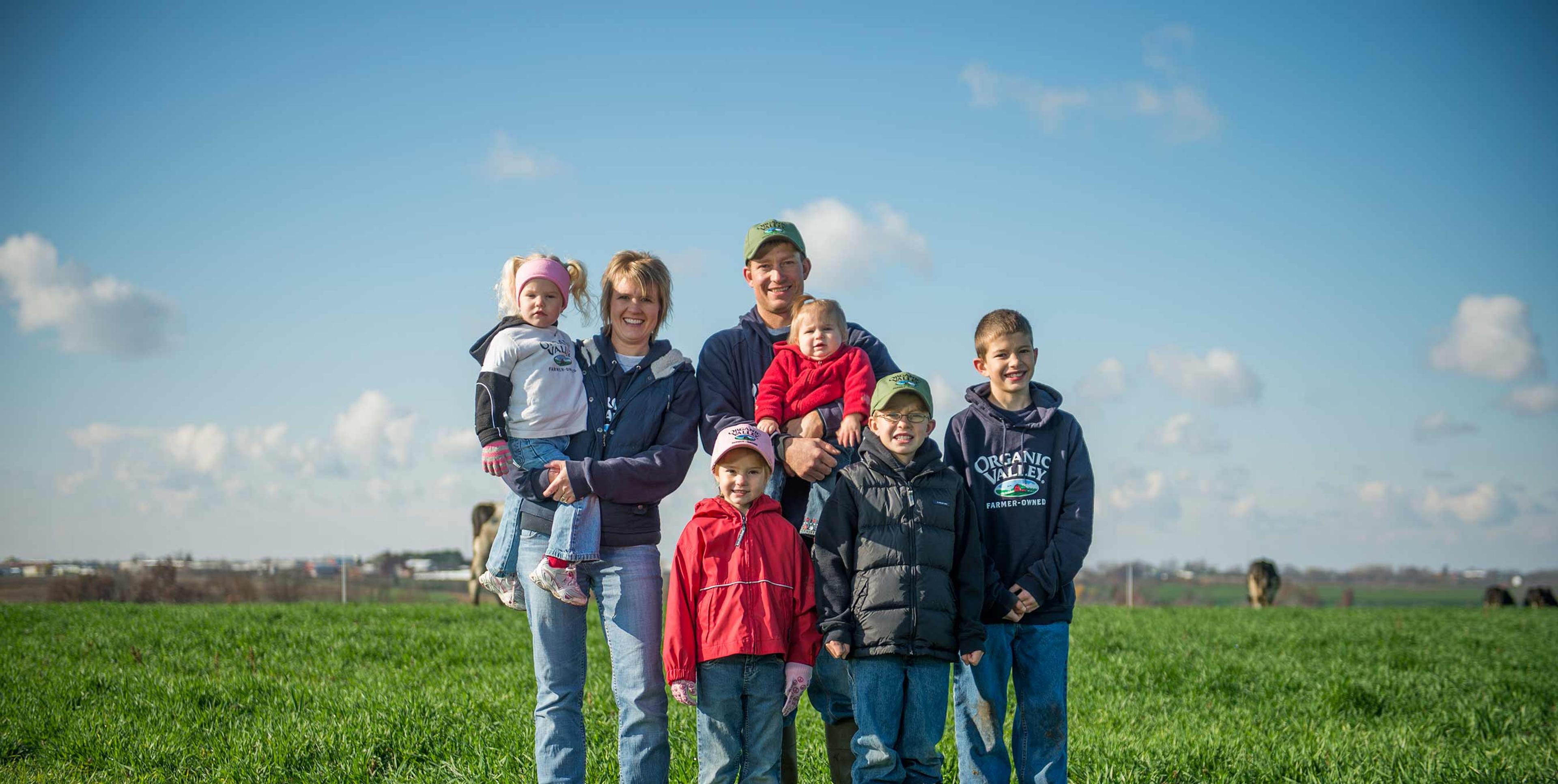 The Ihm family standing together on their farm, Organic View, in Lancaster, WI.