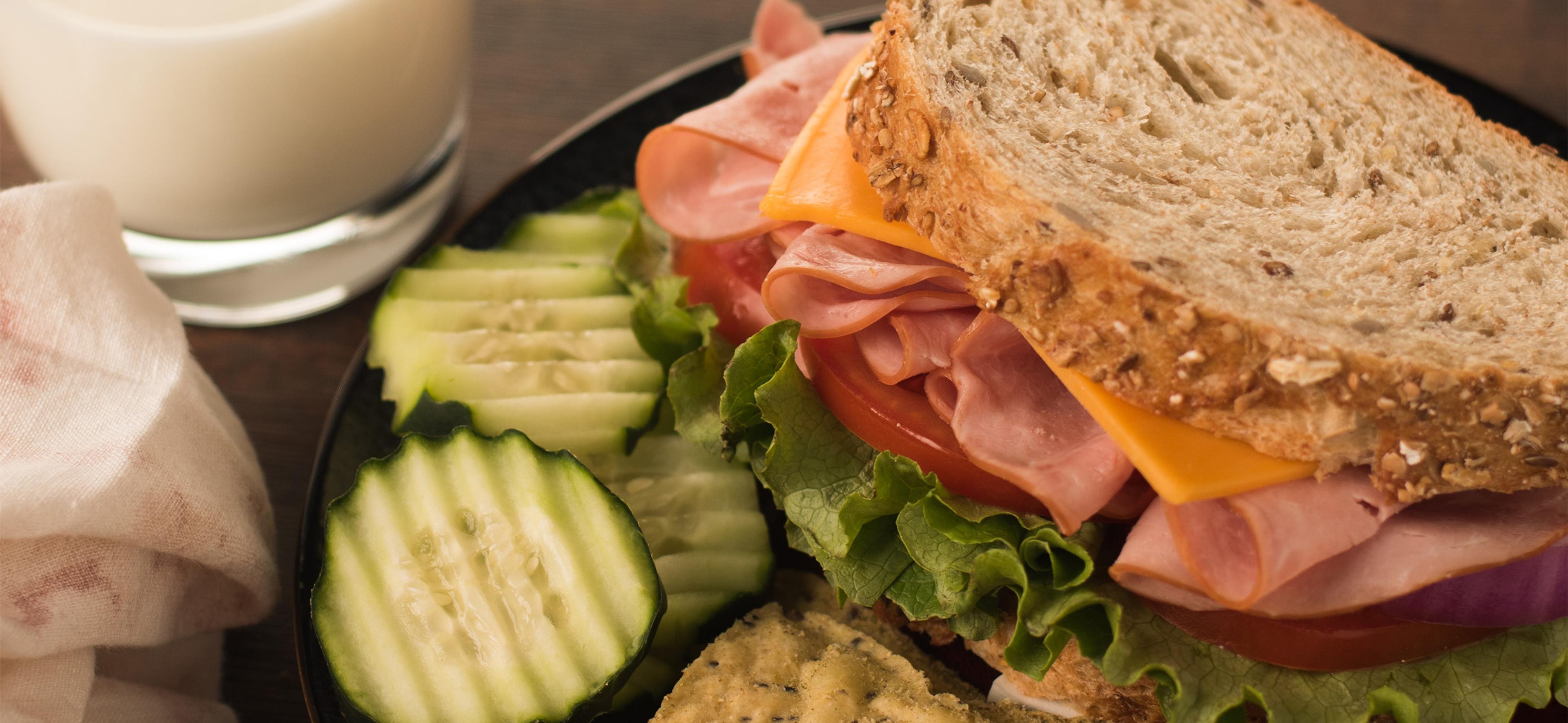 A sandwich with deli meat, cheese and lettuce.