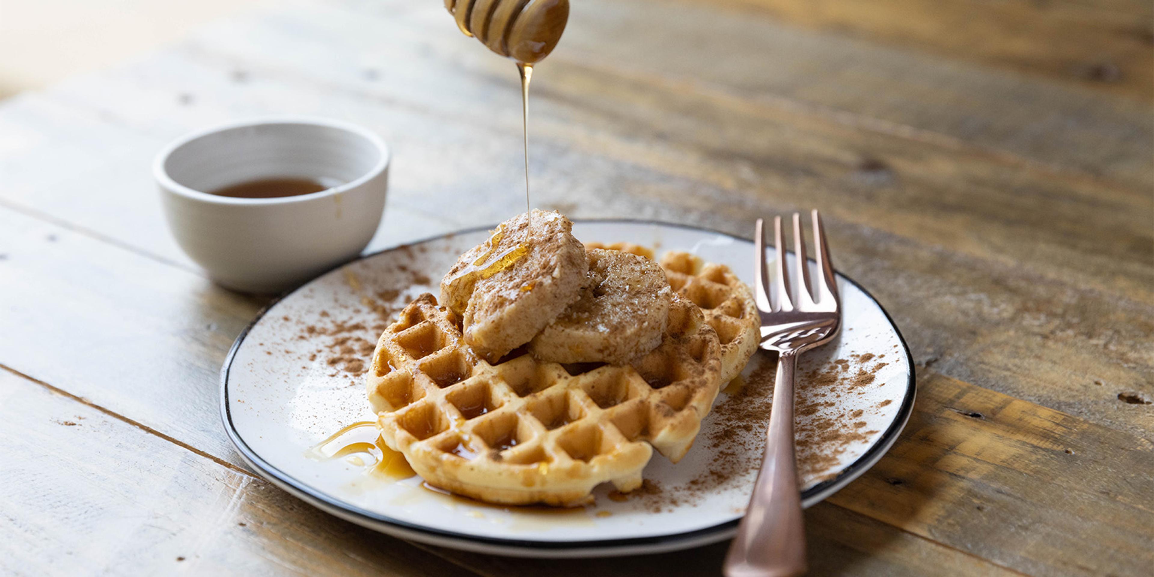 Honey is drizzled over a plate of waffles topped with Cinnamon Compound Butter.