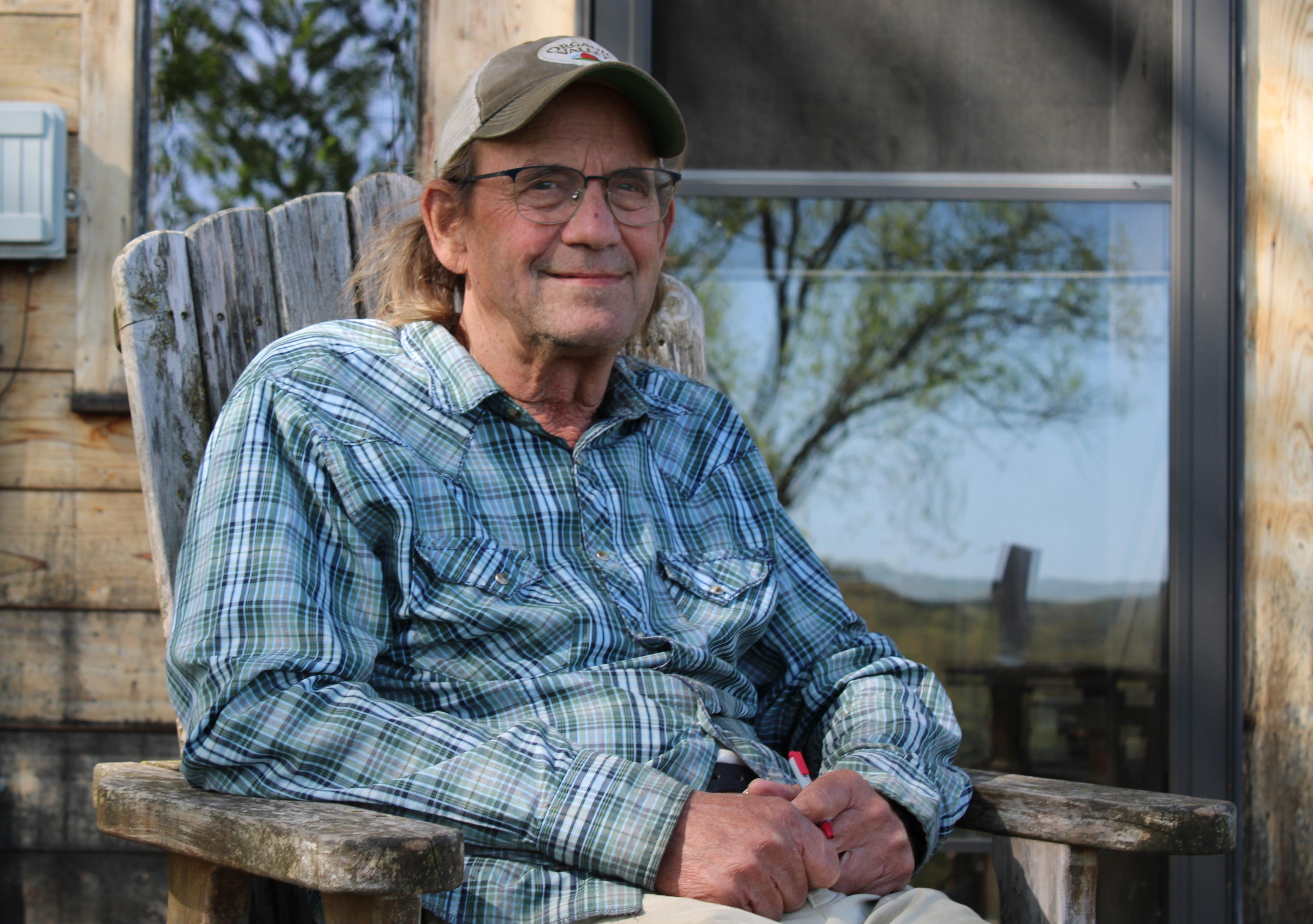George Siemon sits in a chair outdoors at his home near La Farge, Wisconsin.