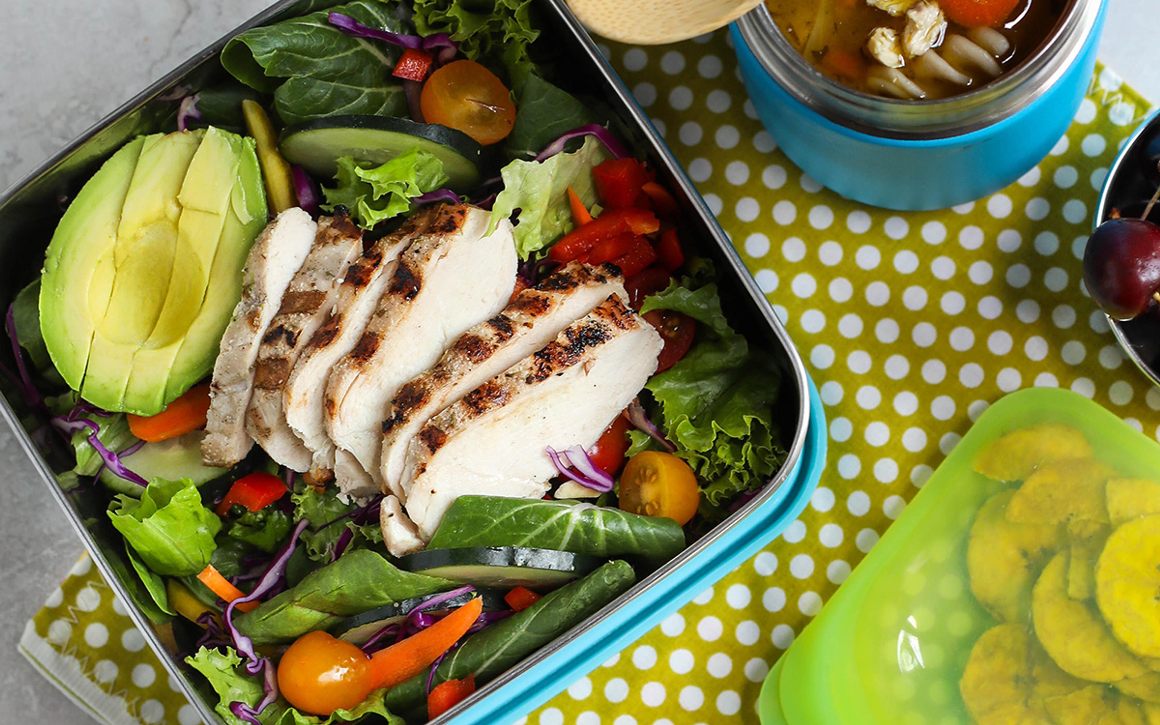 A lunch all ready to eat, including a fresh chicken salad, soup and fresh fruit.