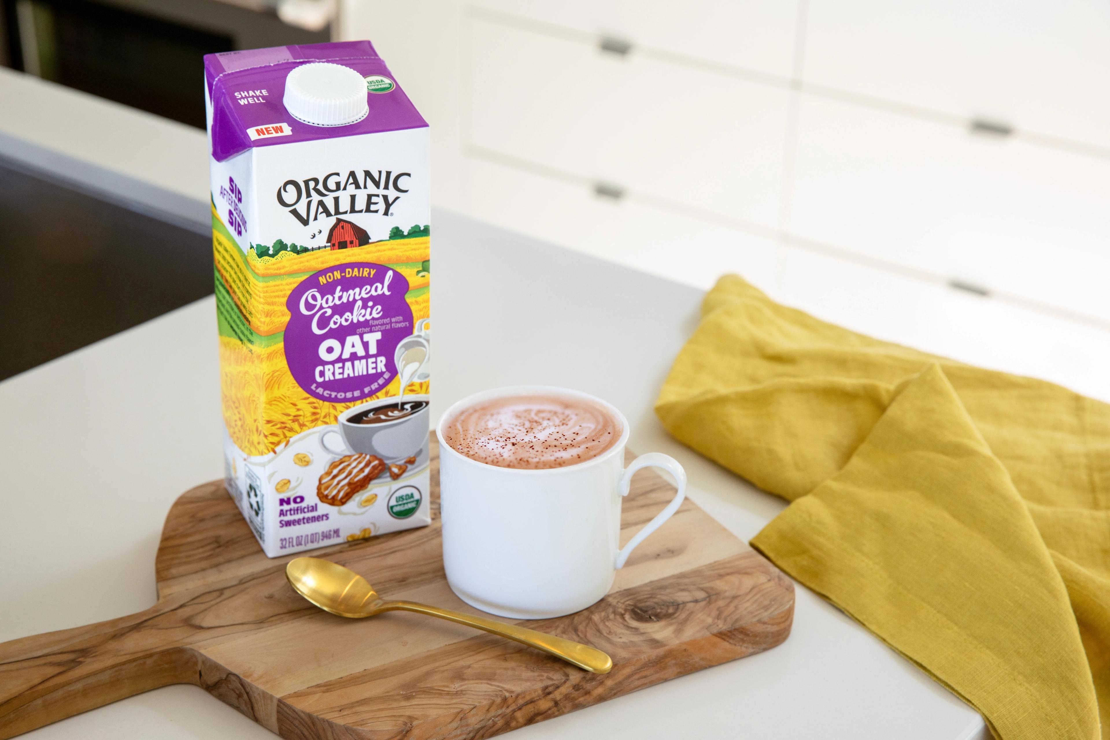 Organic Valley® Oatmeal Cookie Oat Creamer pictured next to a cup of coffee on a kitchen counter.    