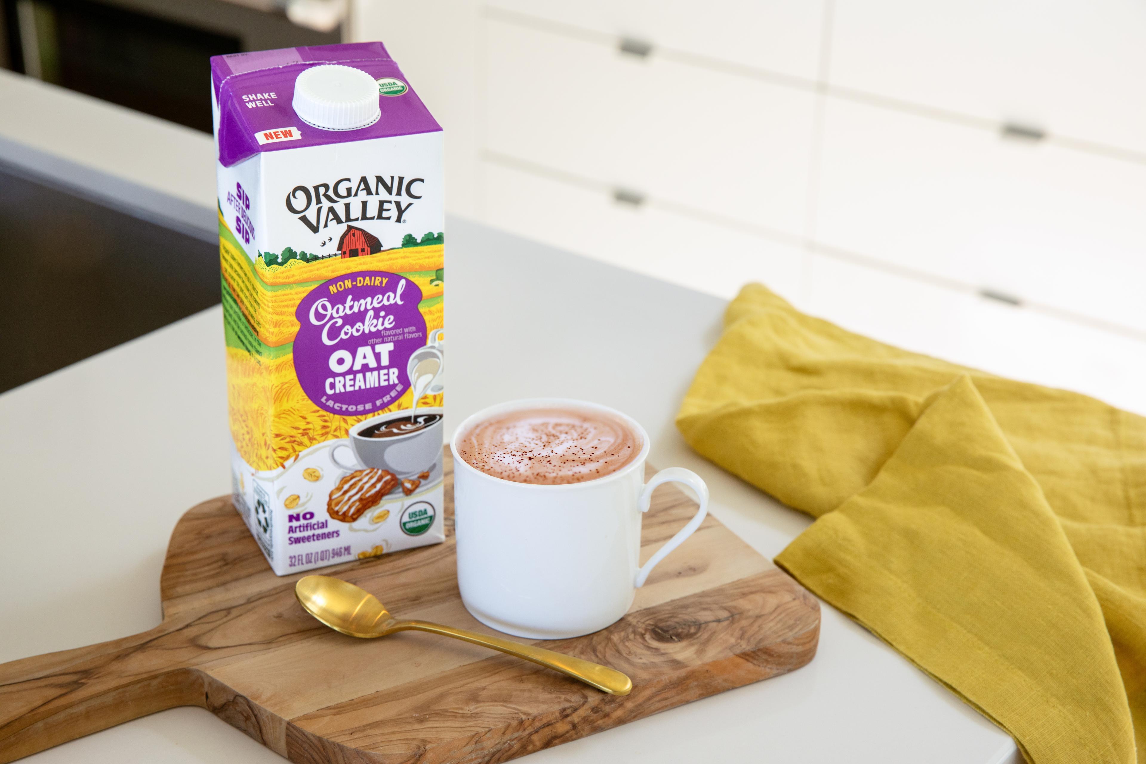 Organic Valley® Oatmeal Cookie Oat Creamer pictured next to a cup of coffee on a kitchen counter.