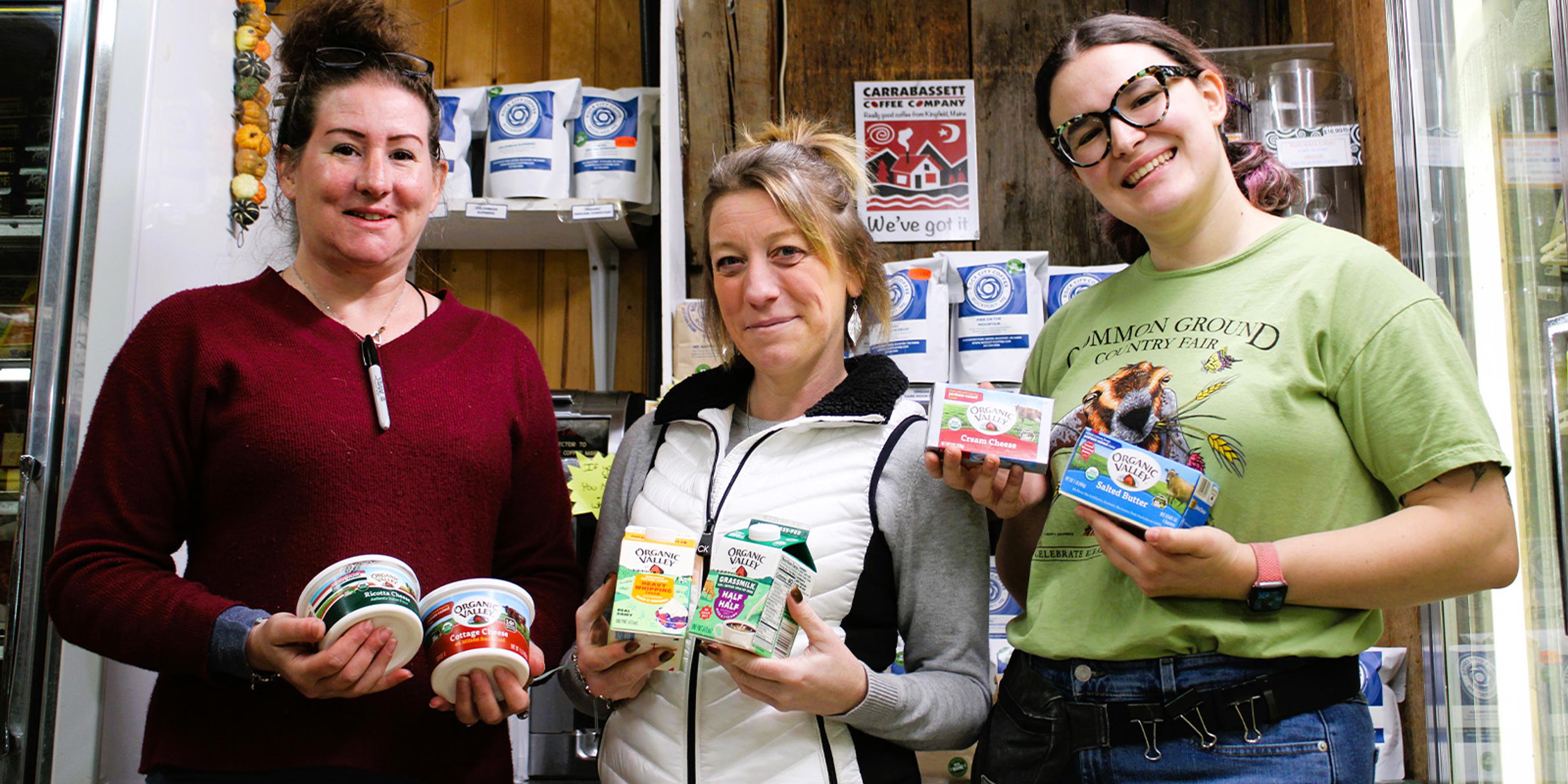 Three women hold Organic Valley products.