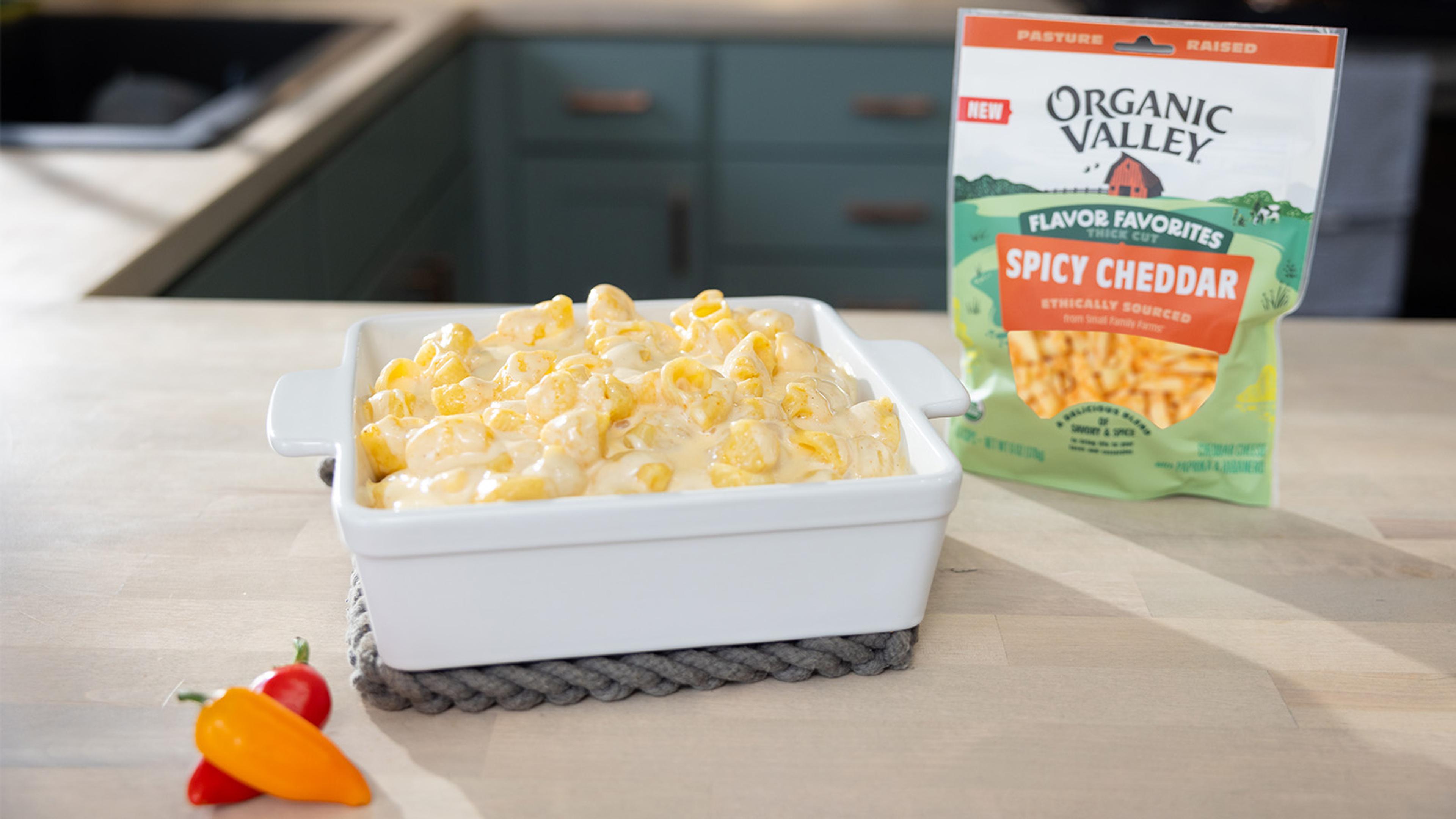 Mac and Cheese on a counter with cheese and peppers next to it.