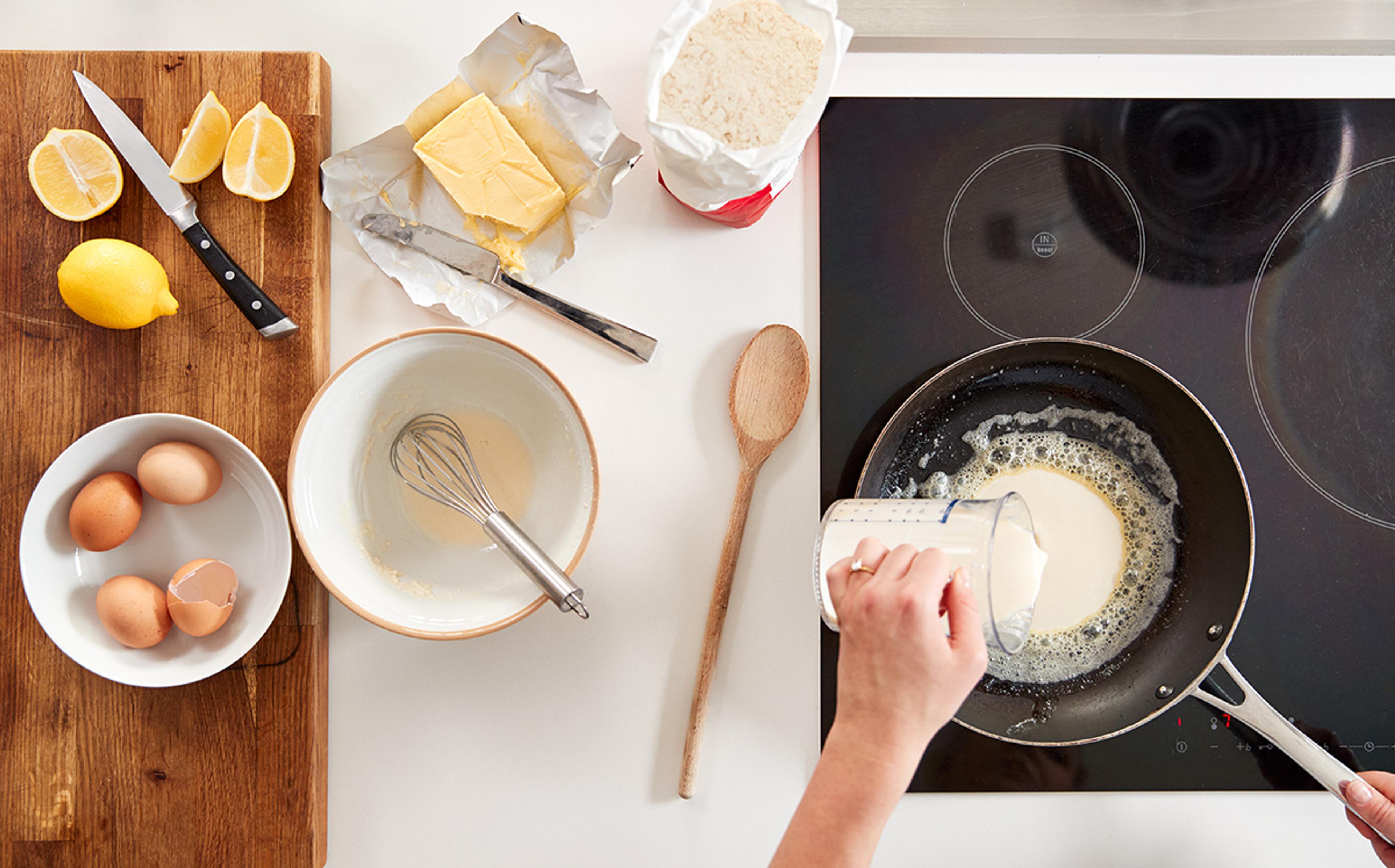 Overhead shot of crepe batter being poured into the pan.