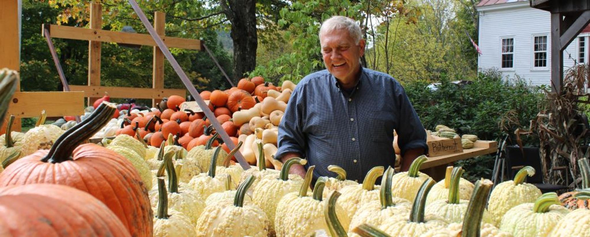 Randall Bates surrounded by trailers full of pumpkins.