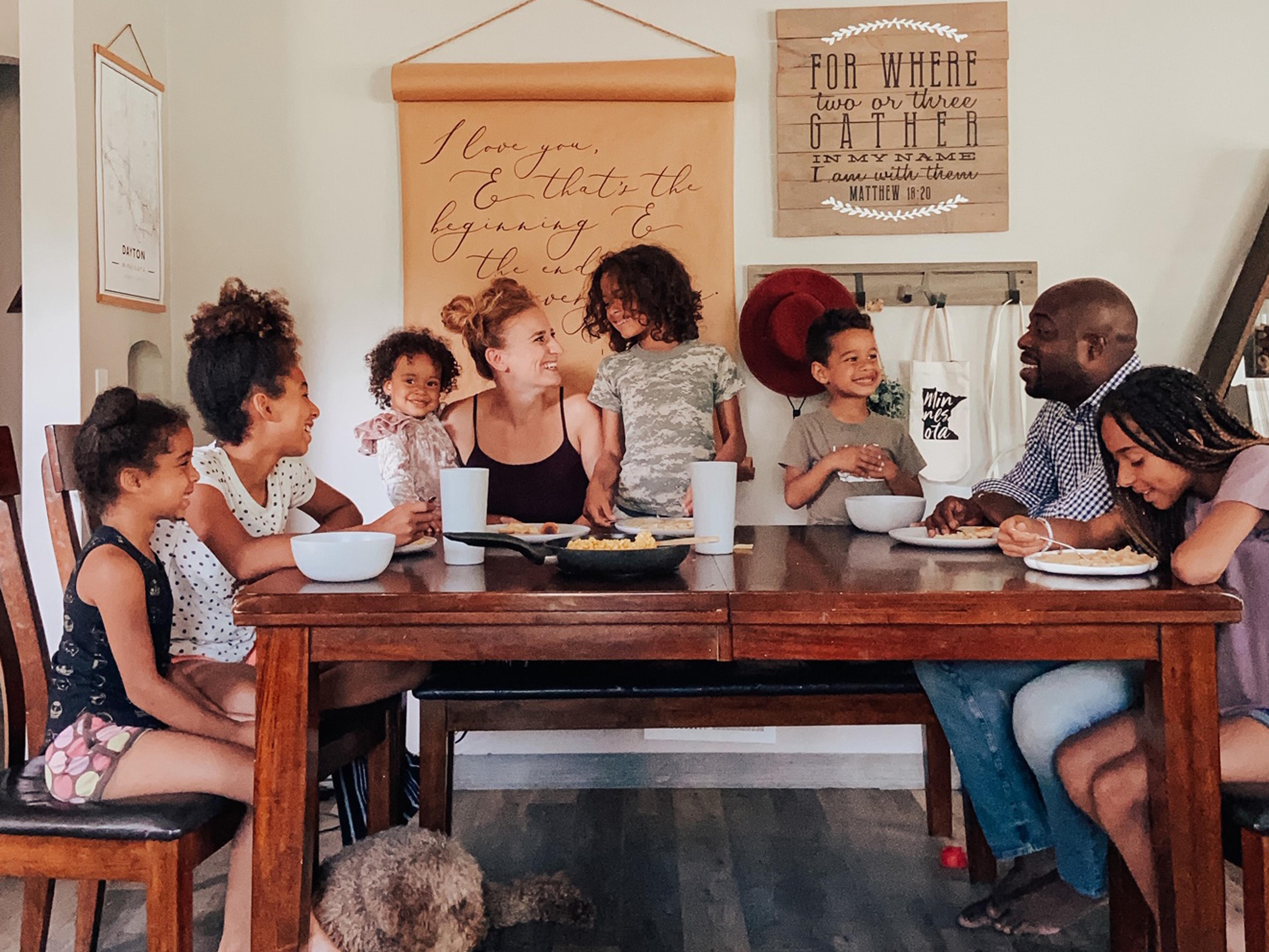 Family of 8 sit around the dinner table.
