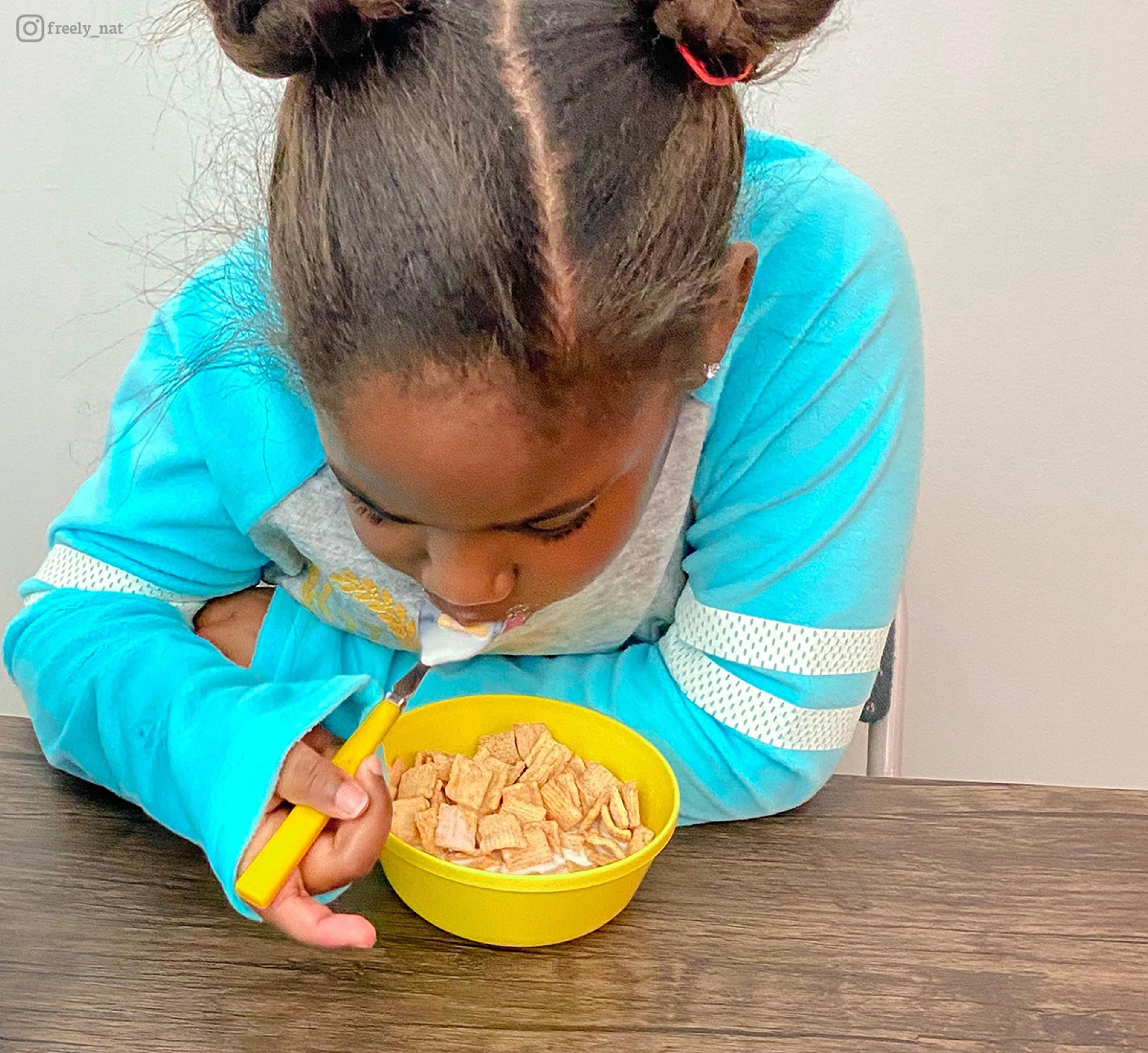 Young girl enjoys a bowl of milk and cereal. Photo contribute by @freely_nat.