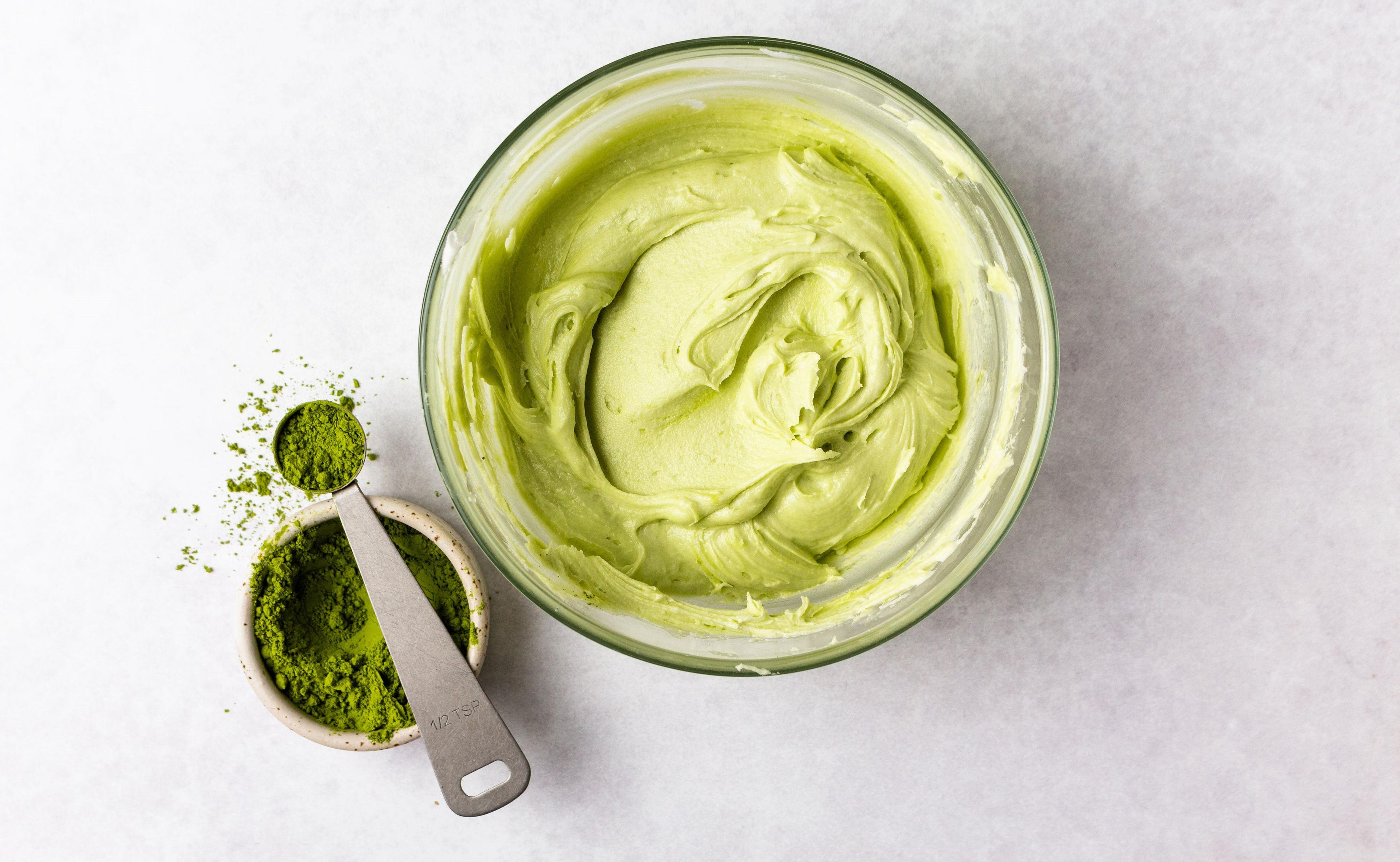 Matcha powder next to green frosting.