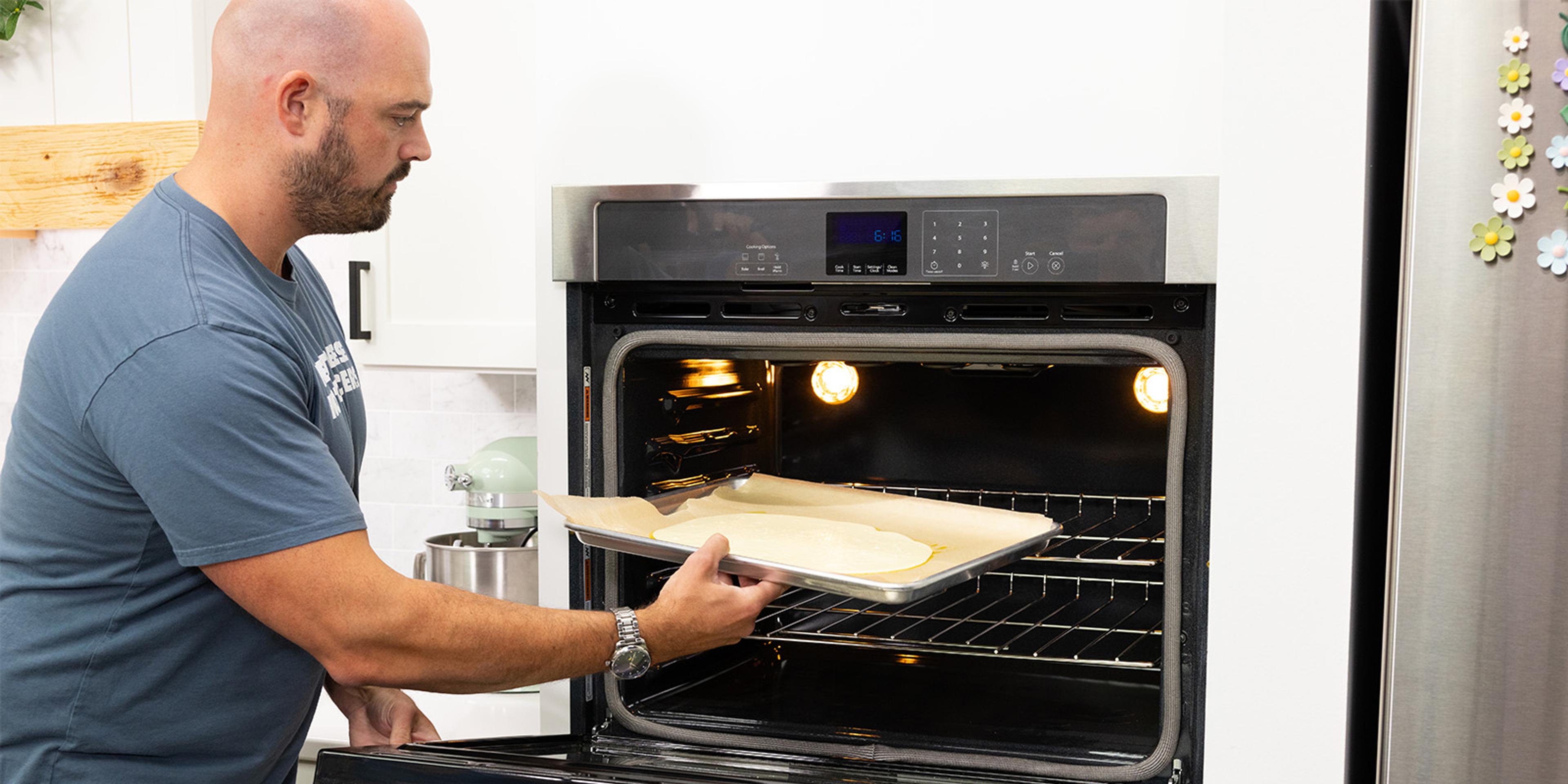  A man puts a pan in the oven. 