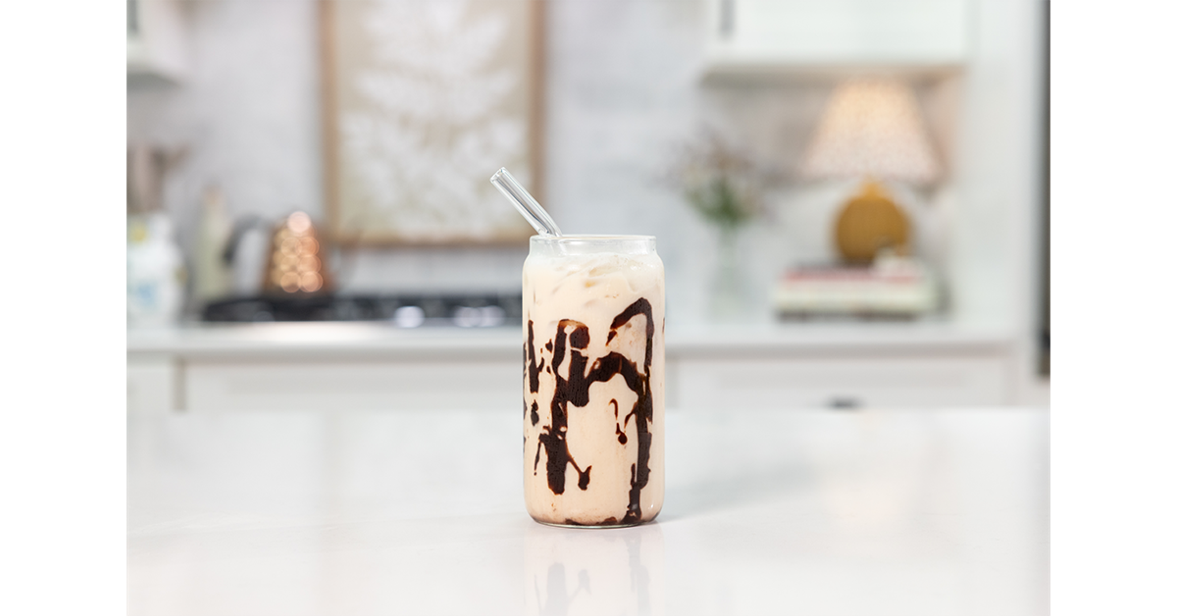 Peanut Butter Banana Mocha drink with a straw on a counter.