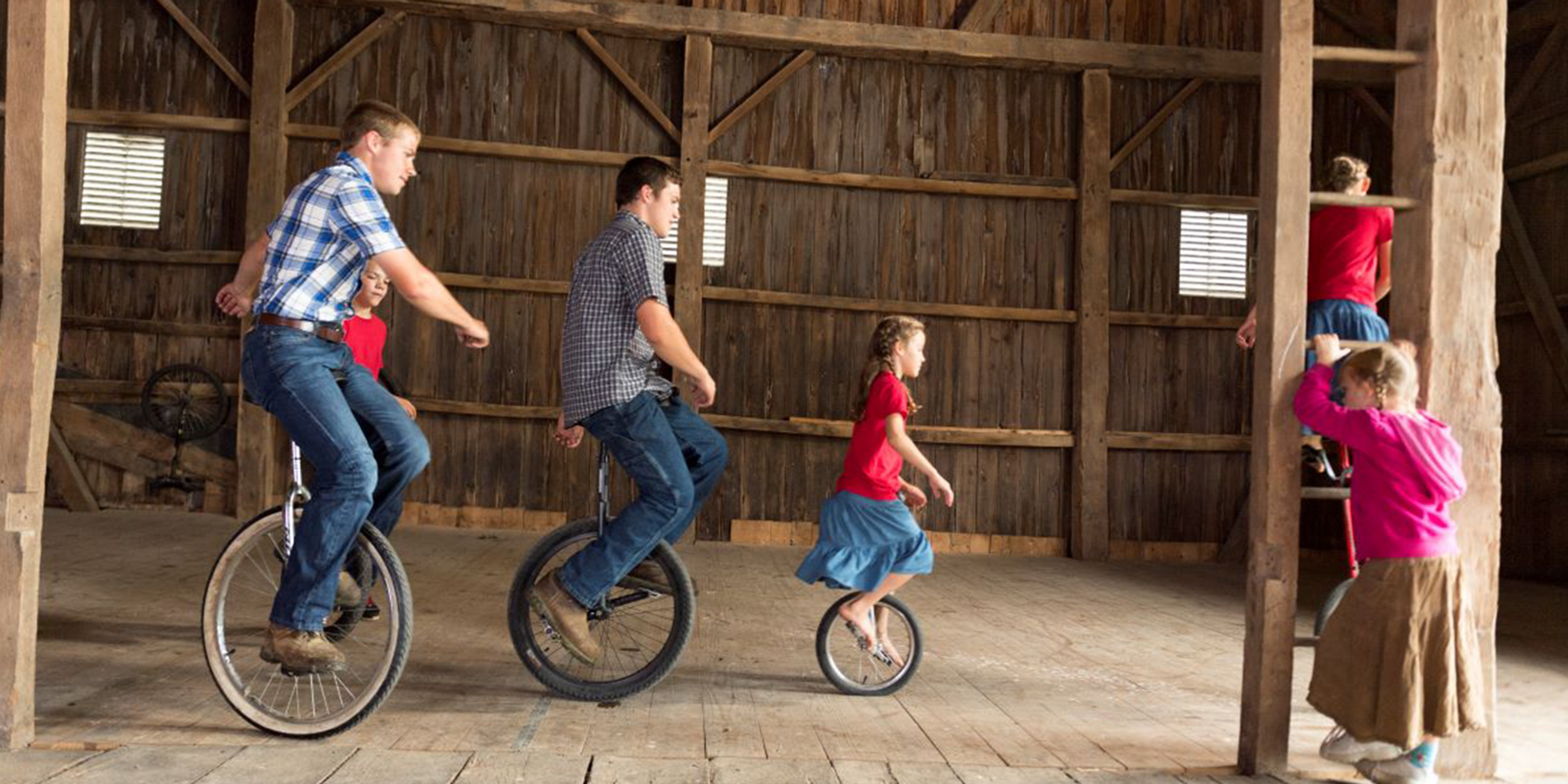 Stoller family members ride unicycles in their barn in Ohio.