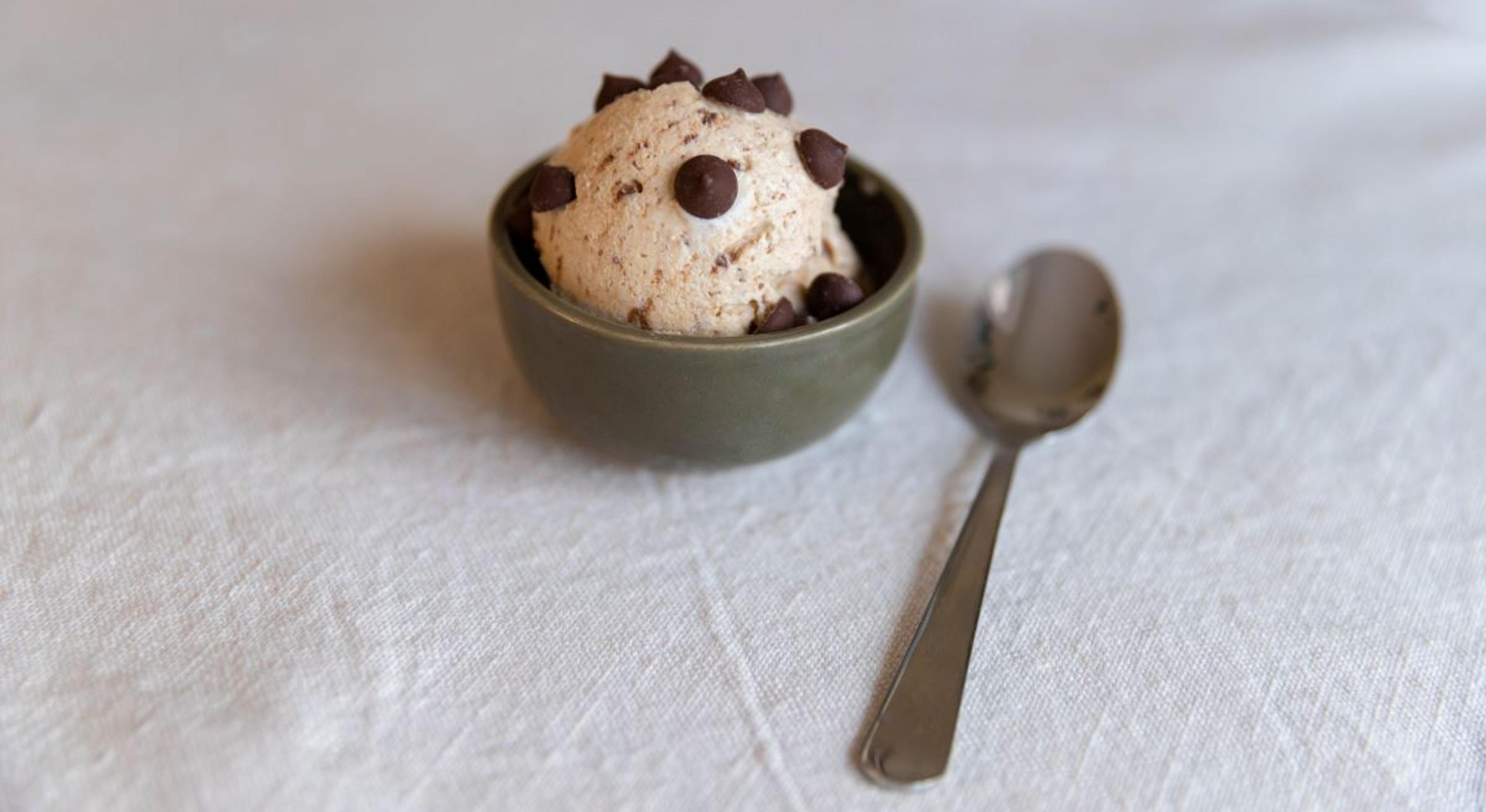 Peanut Butter Chocolate Chip Cottage Cheese Ice Cream on a table with a spoon.