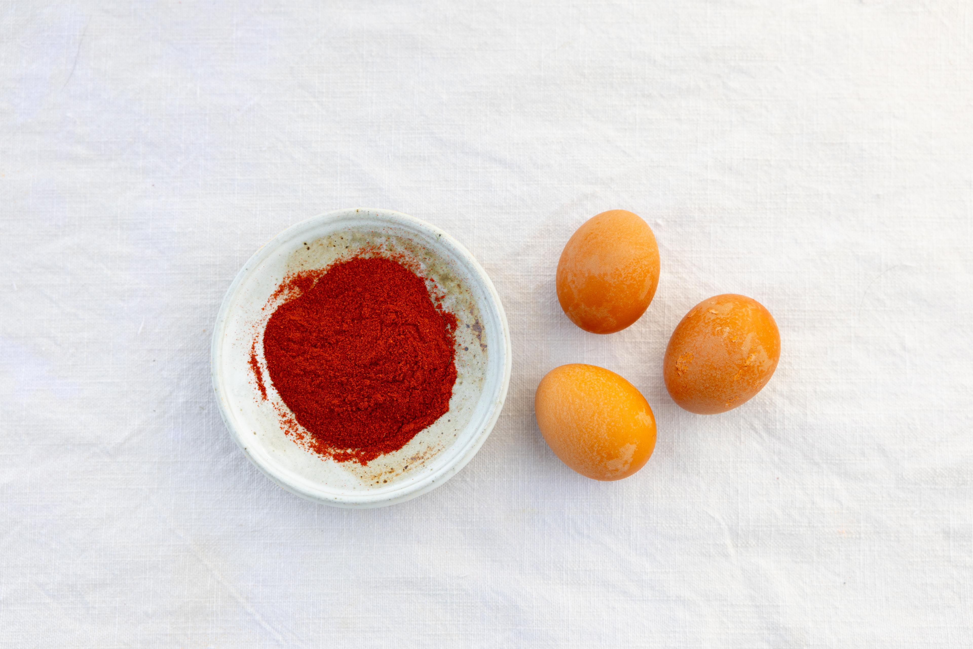 Smoked Spanish paprika in a bowl next to eggs.