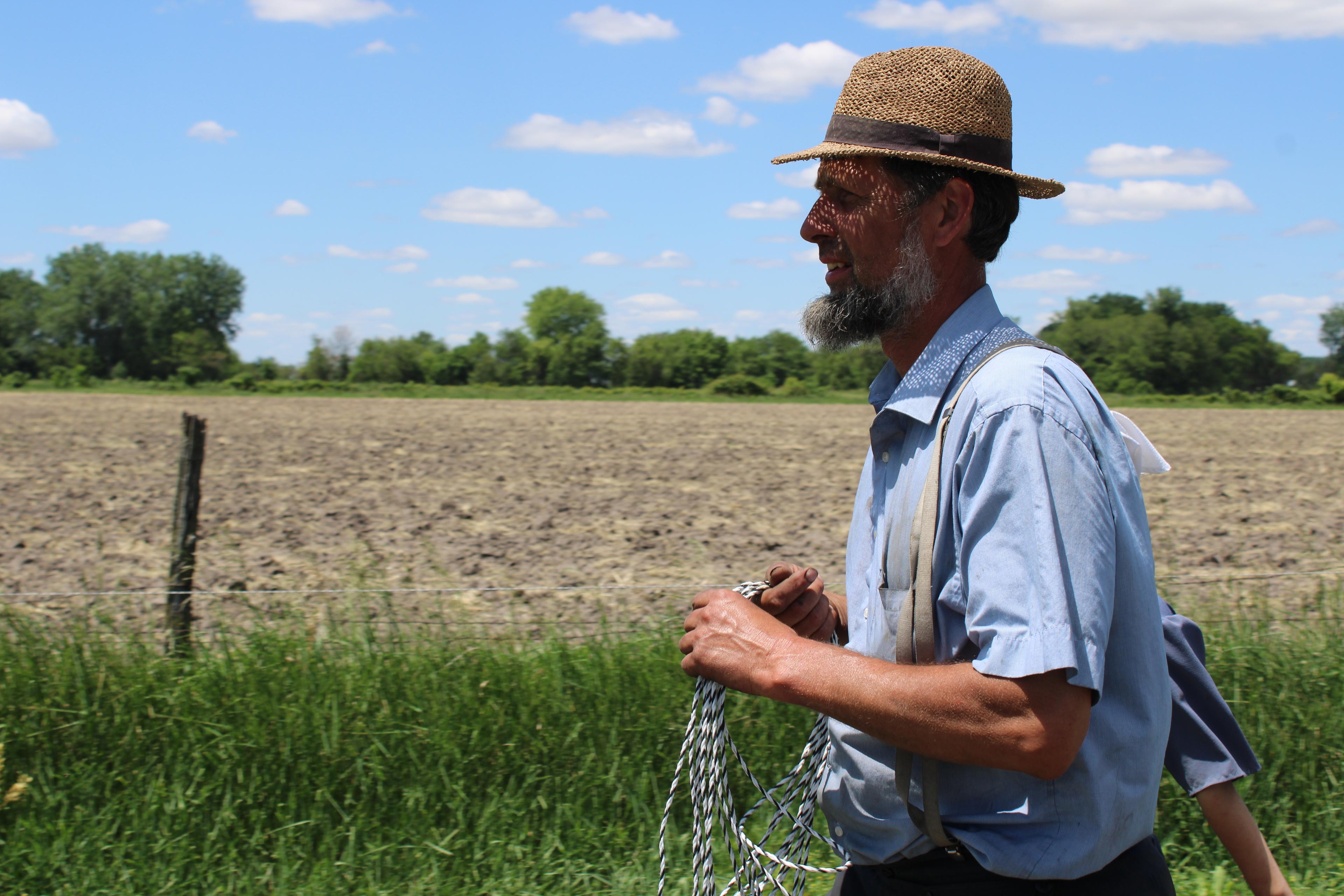 Toby Miller carries fencing to a field.