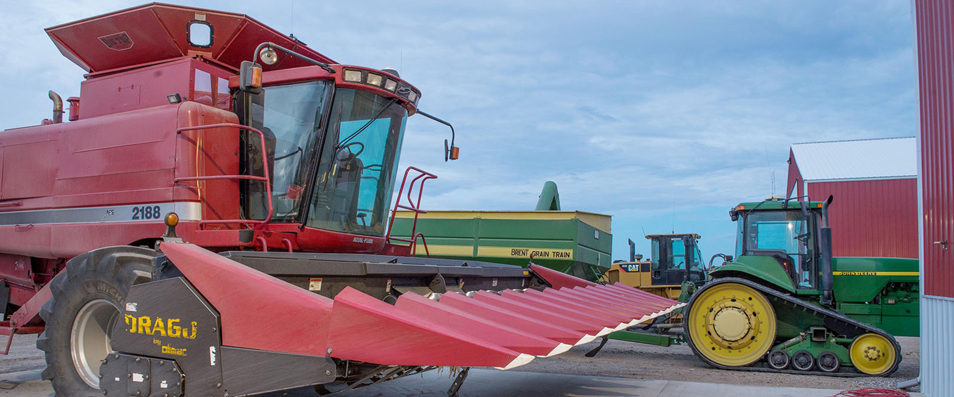 Large corn thresher and smaller tractor