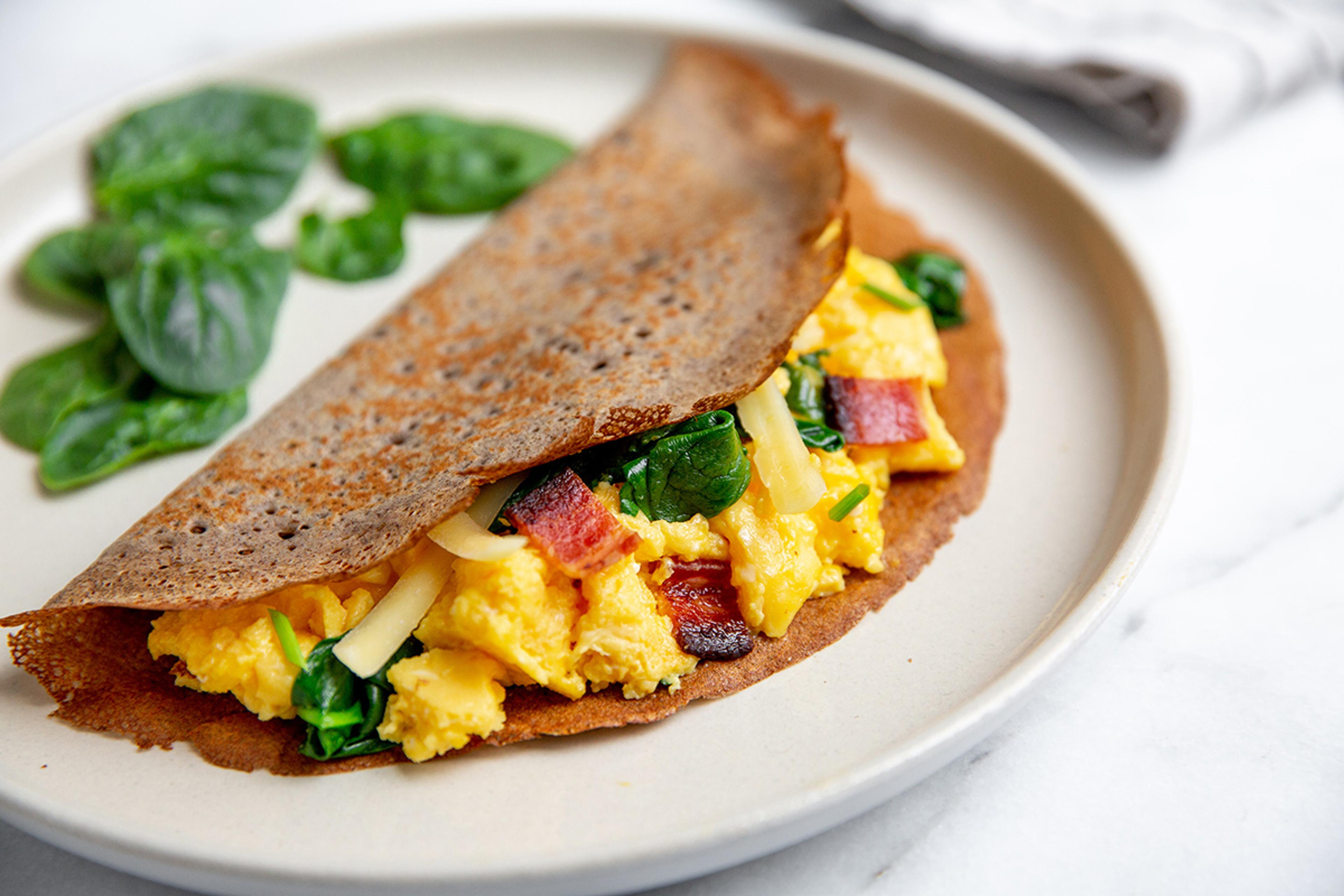 Savory gluten-free crepes filled with scrambled eggs, cheese, spinach and bacon.