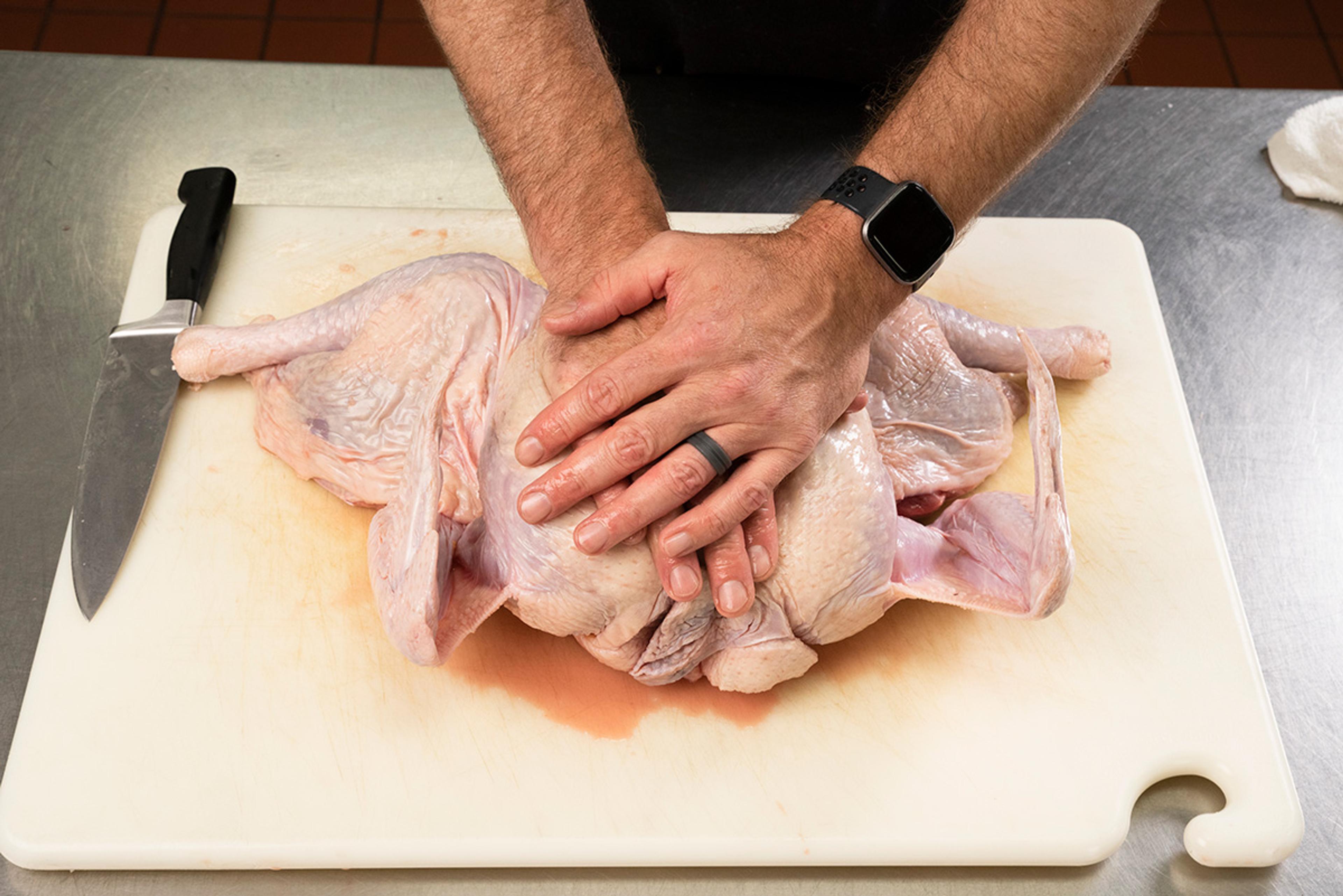 Breaking the breastplate and flattening the bird are the next step to spatchcocking a turkey.