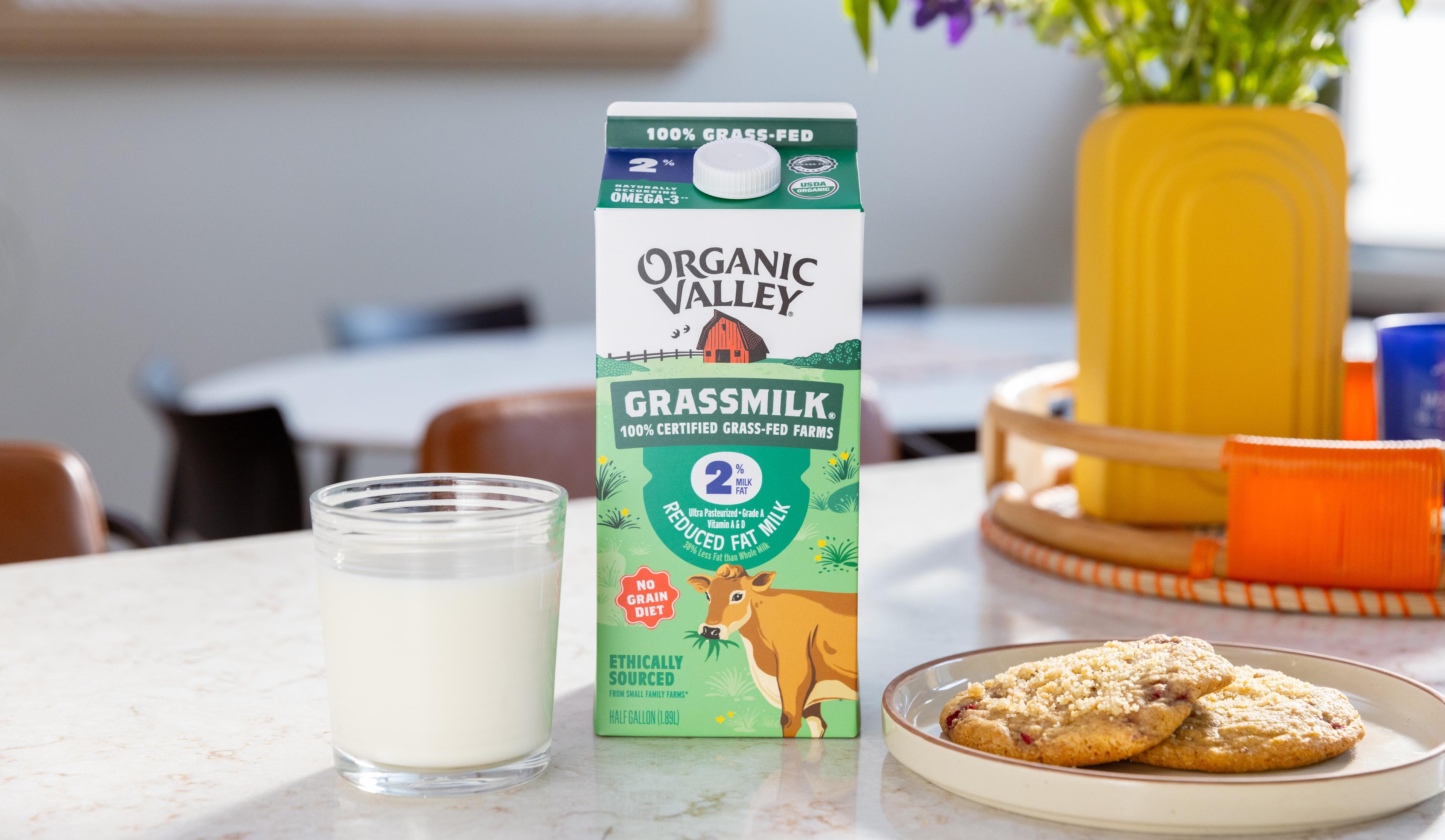 Organic Grassmilk® next to a plate of cookies and vase of flowers.