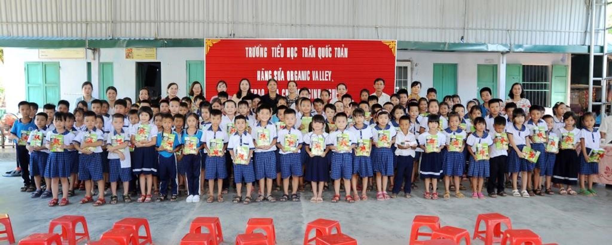 School children in Vietnam hold organic products.