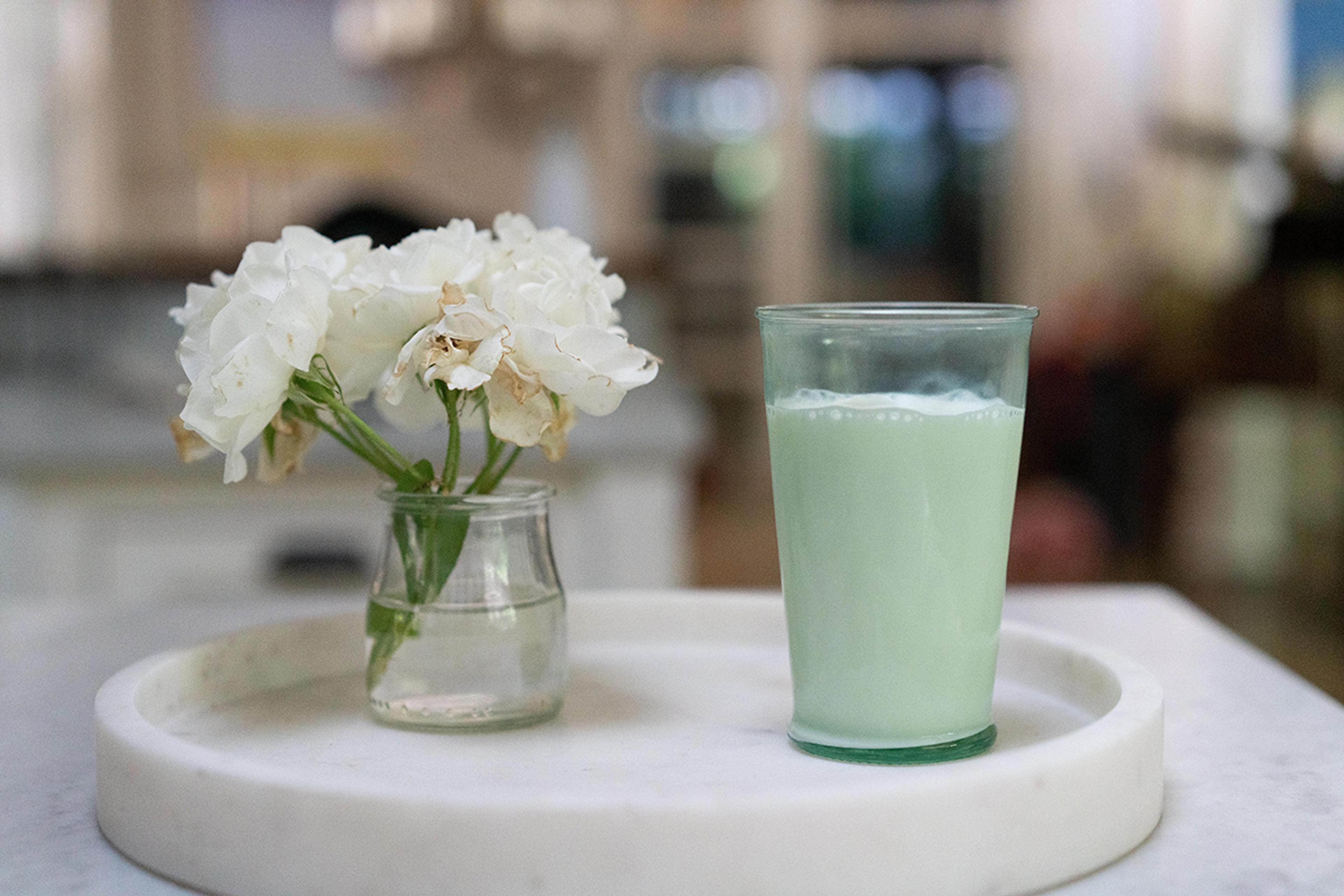 Glass of Organic Valley milk next to a boquet of white flowers.