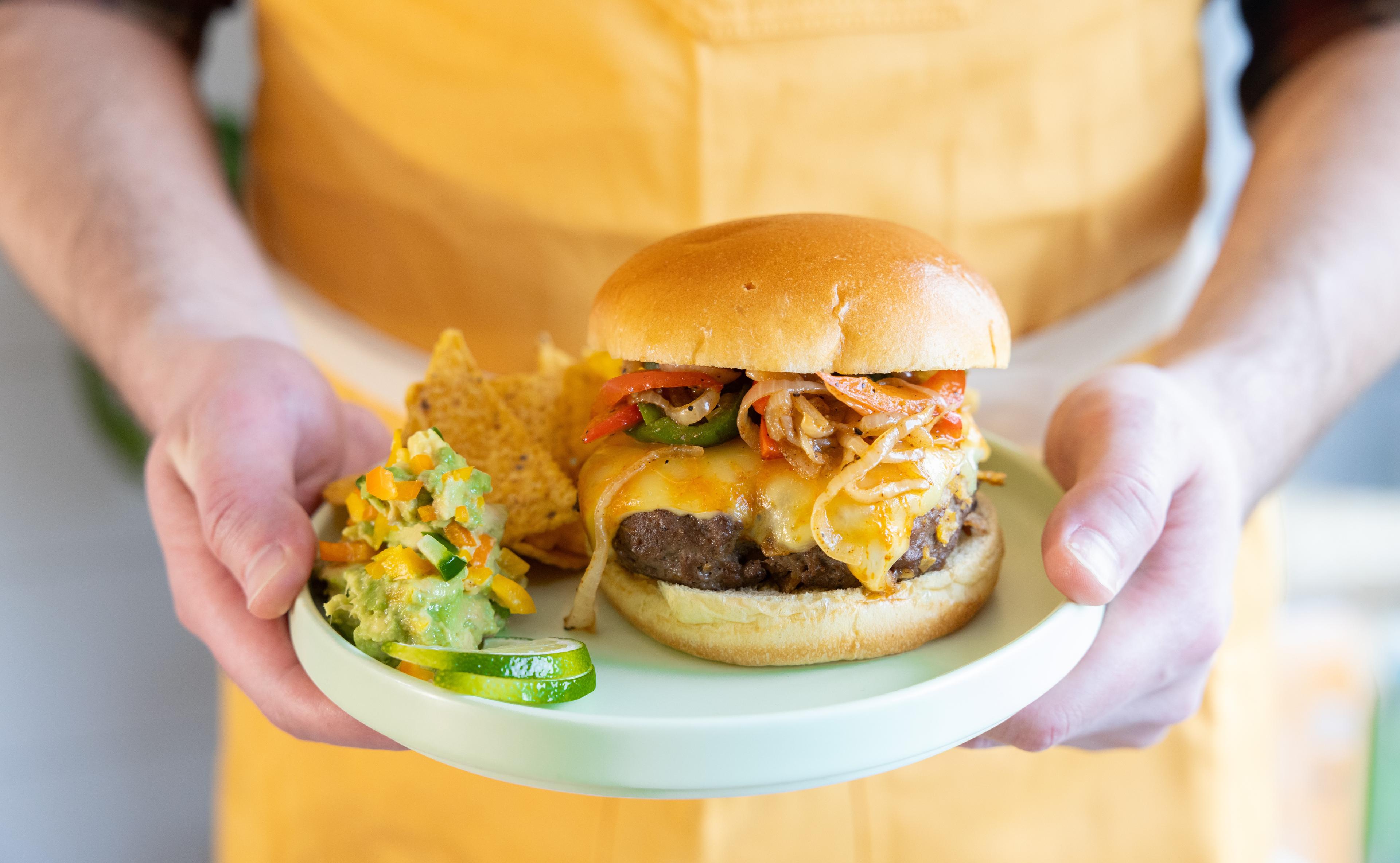 Man carries a Fajita Cheeseburger with Spicy Cheddar