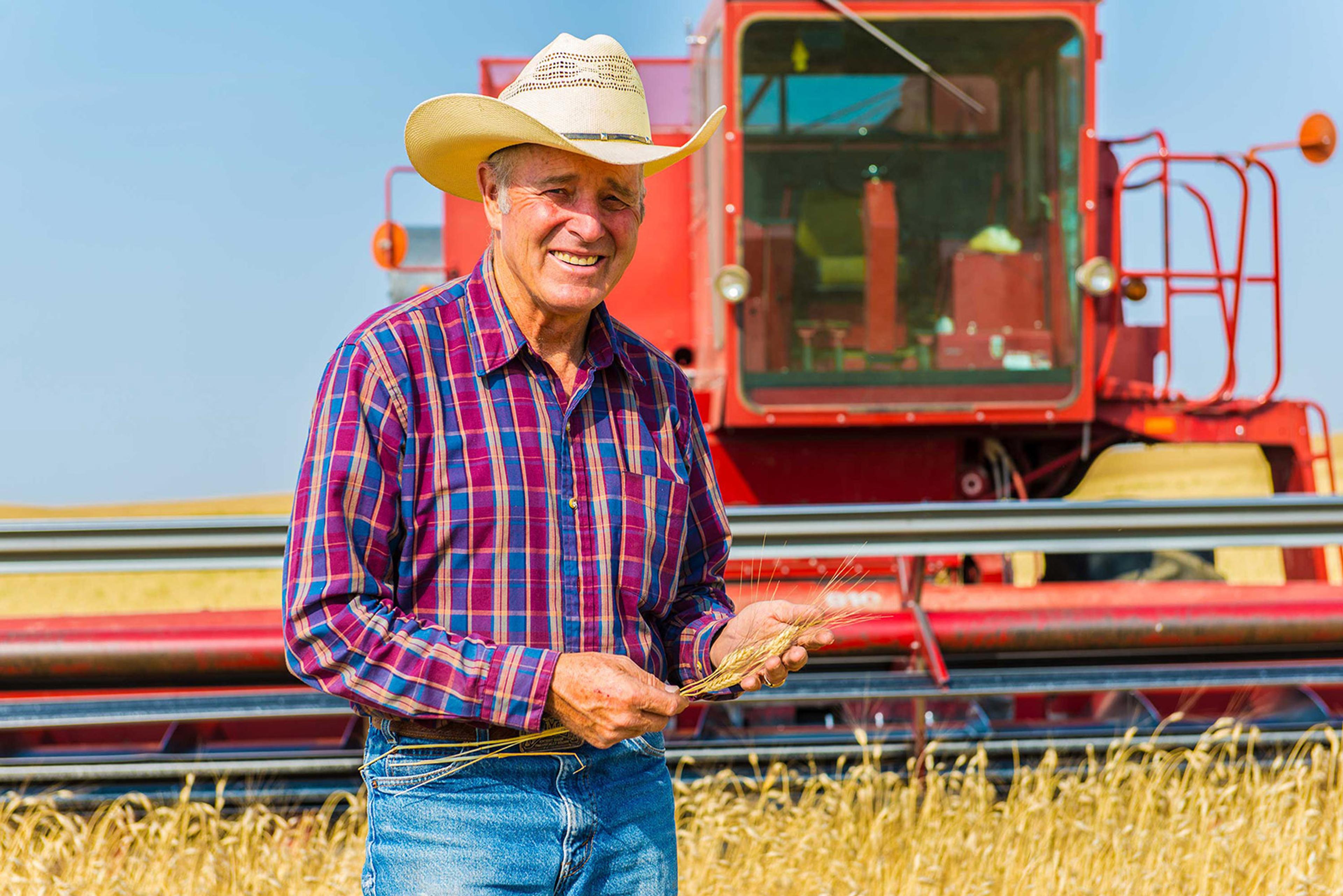 Bob Quinn in front of tractor in field.