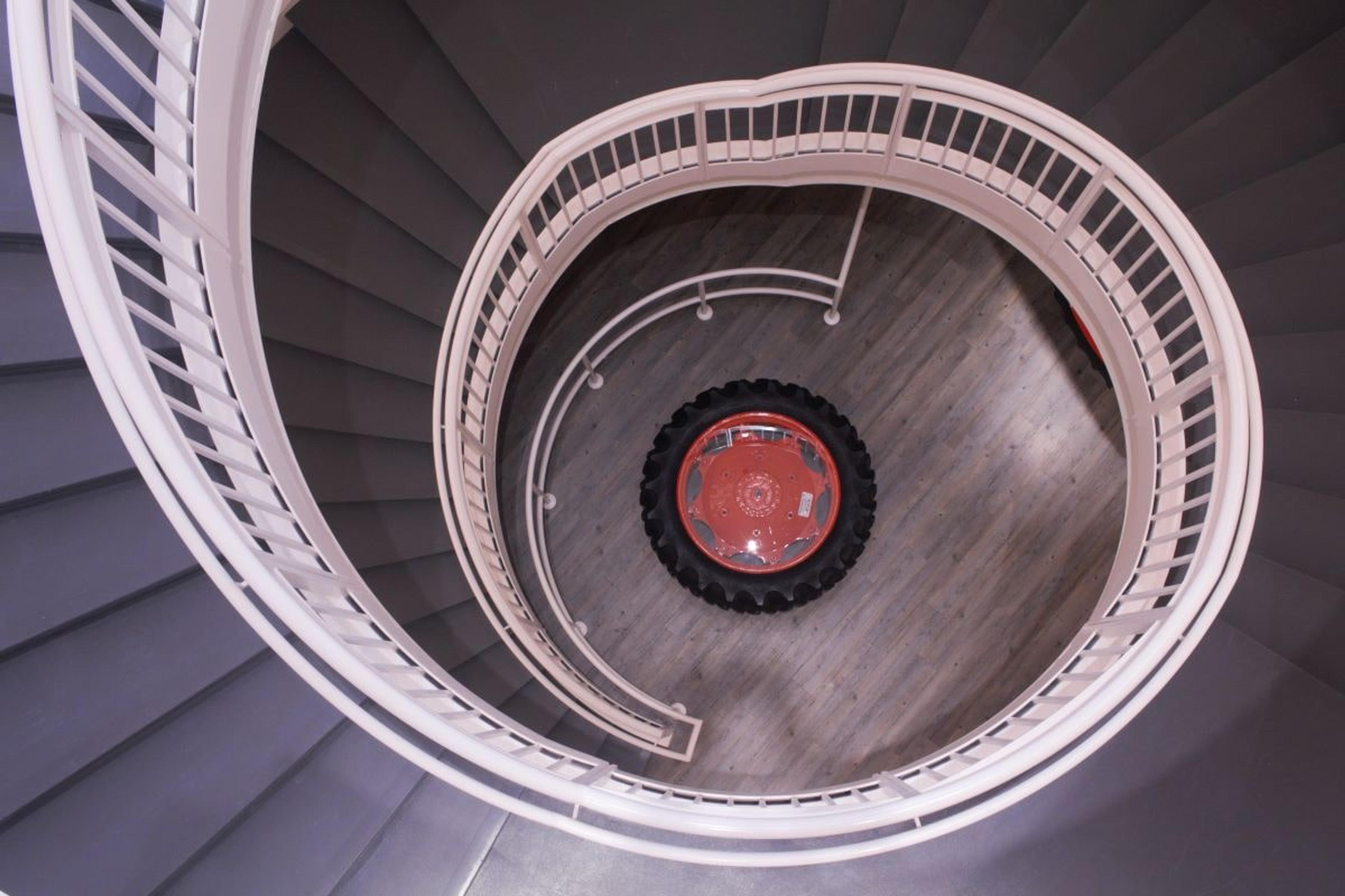 A tractor tire sits at the bottom of the spiral staircase.