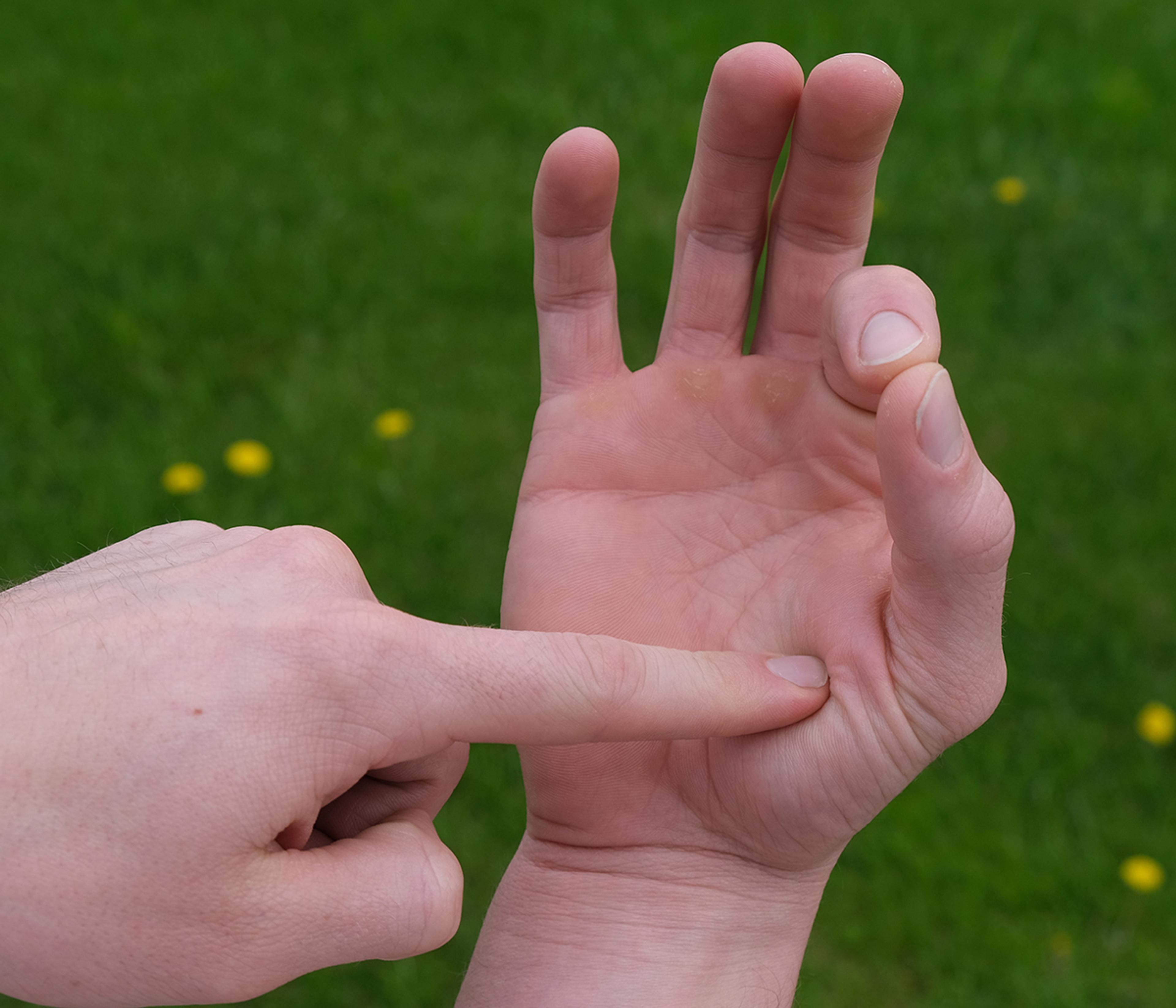 A man points to his hand.