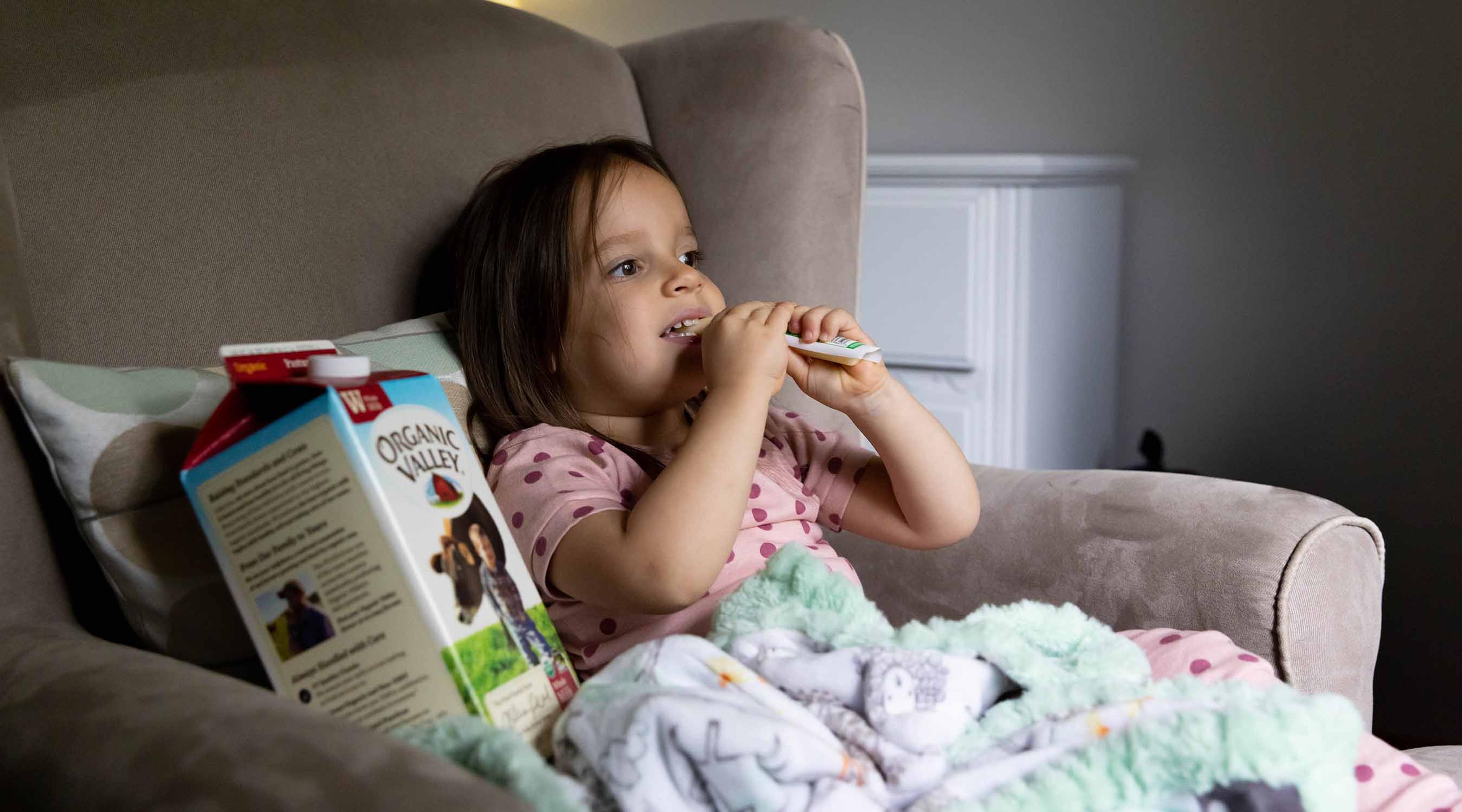 A girl eats string cheese.