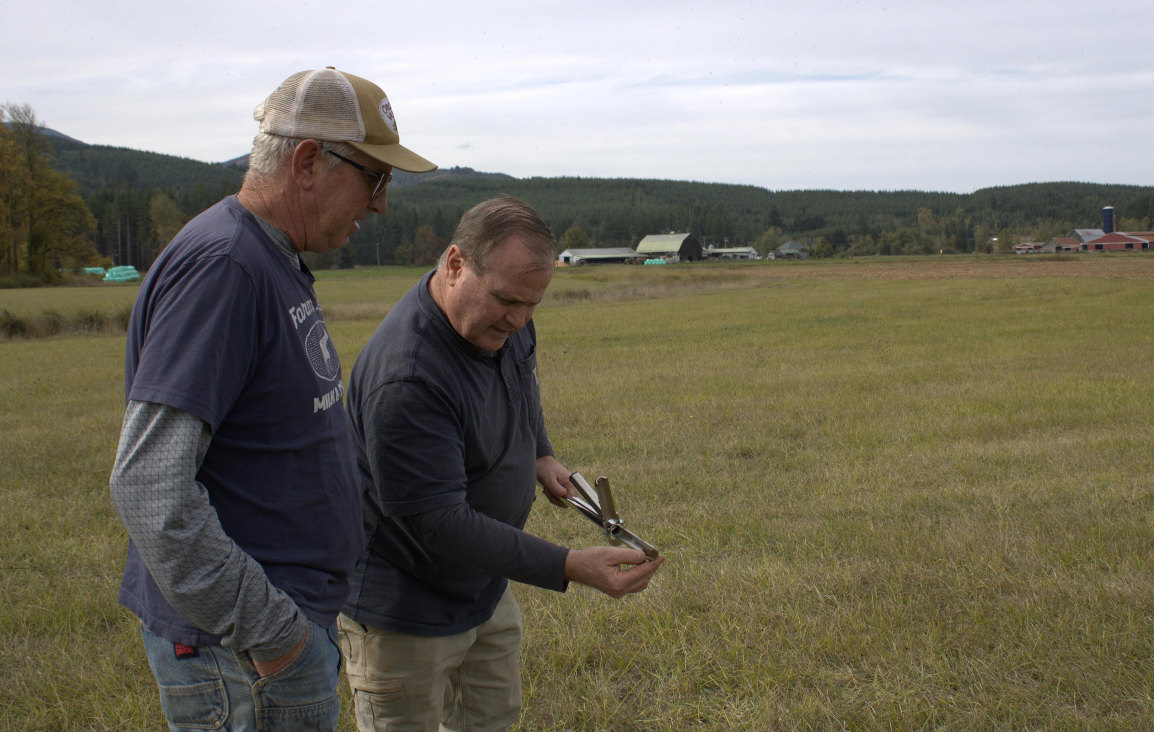 Washington farmer Maynard Mallonee, left, and Basic Dust CEO Mike Robinson examine a soil sample.