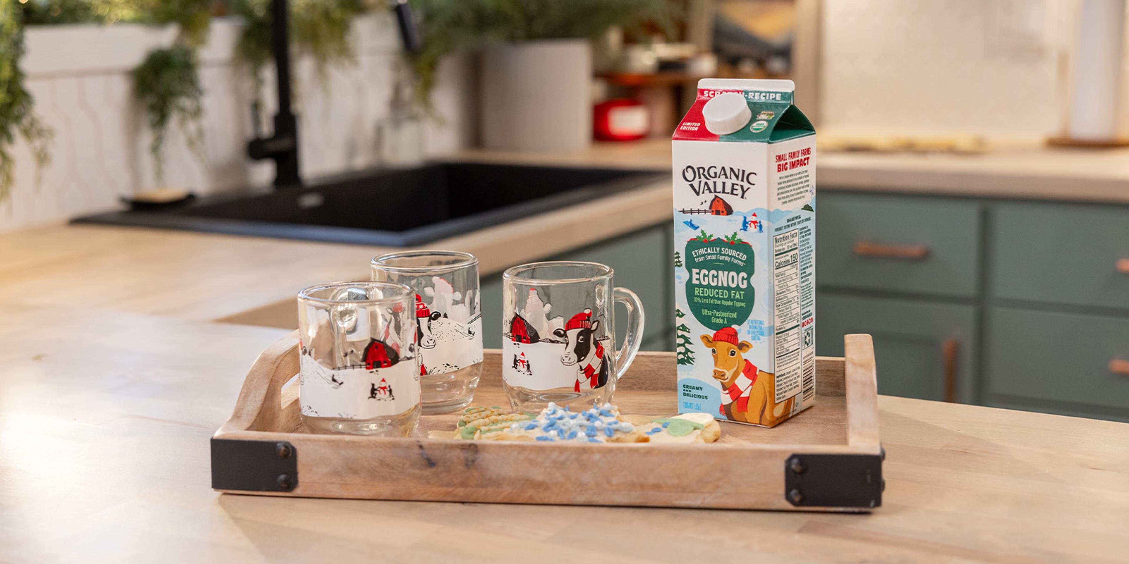 A carton of organic eggnog on a tray with glasses.