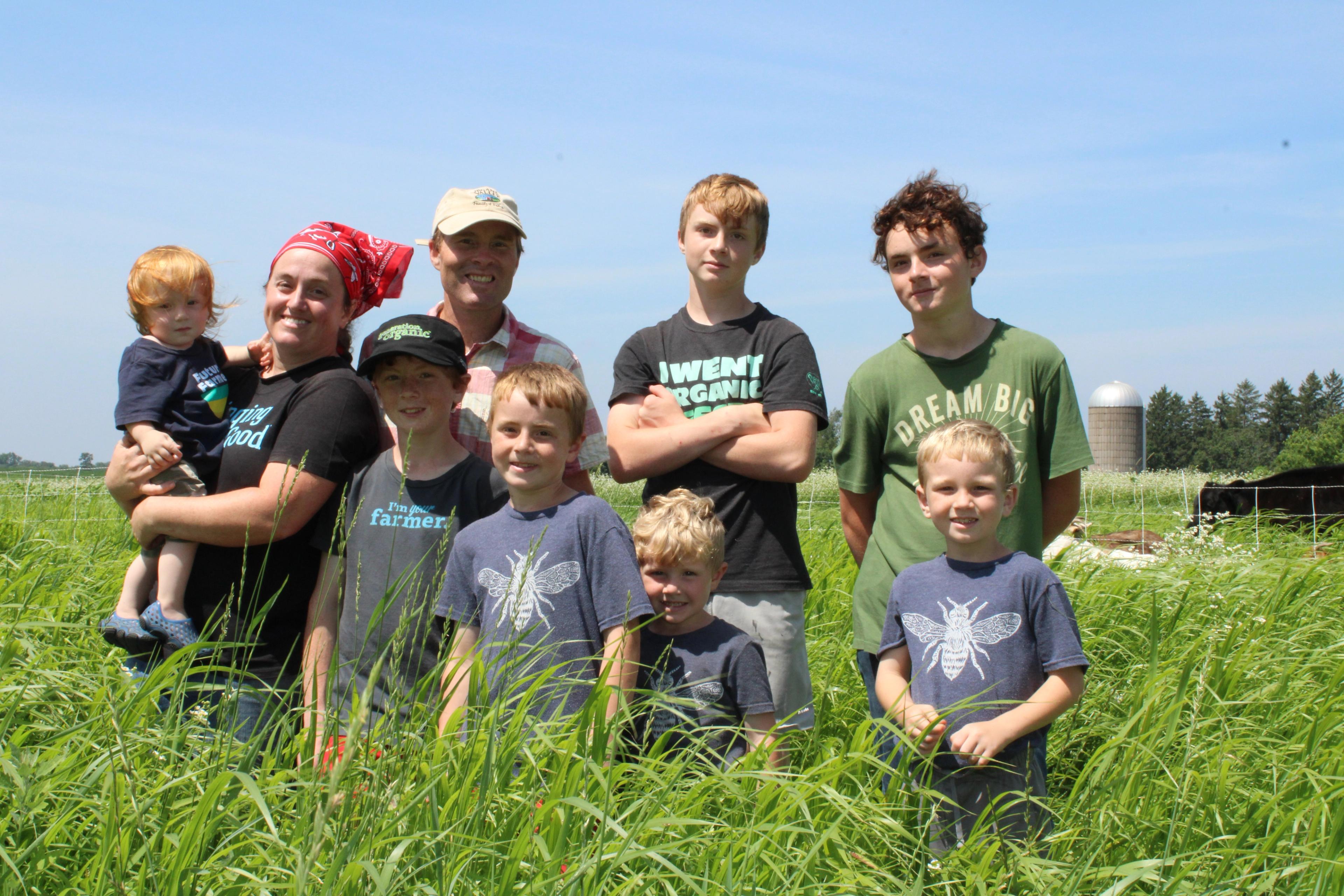 Klein family members pose on a field of grasses. 