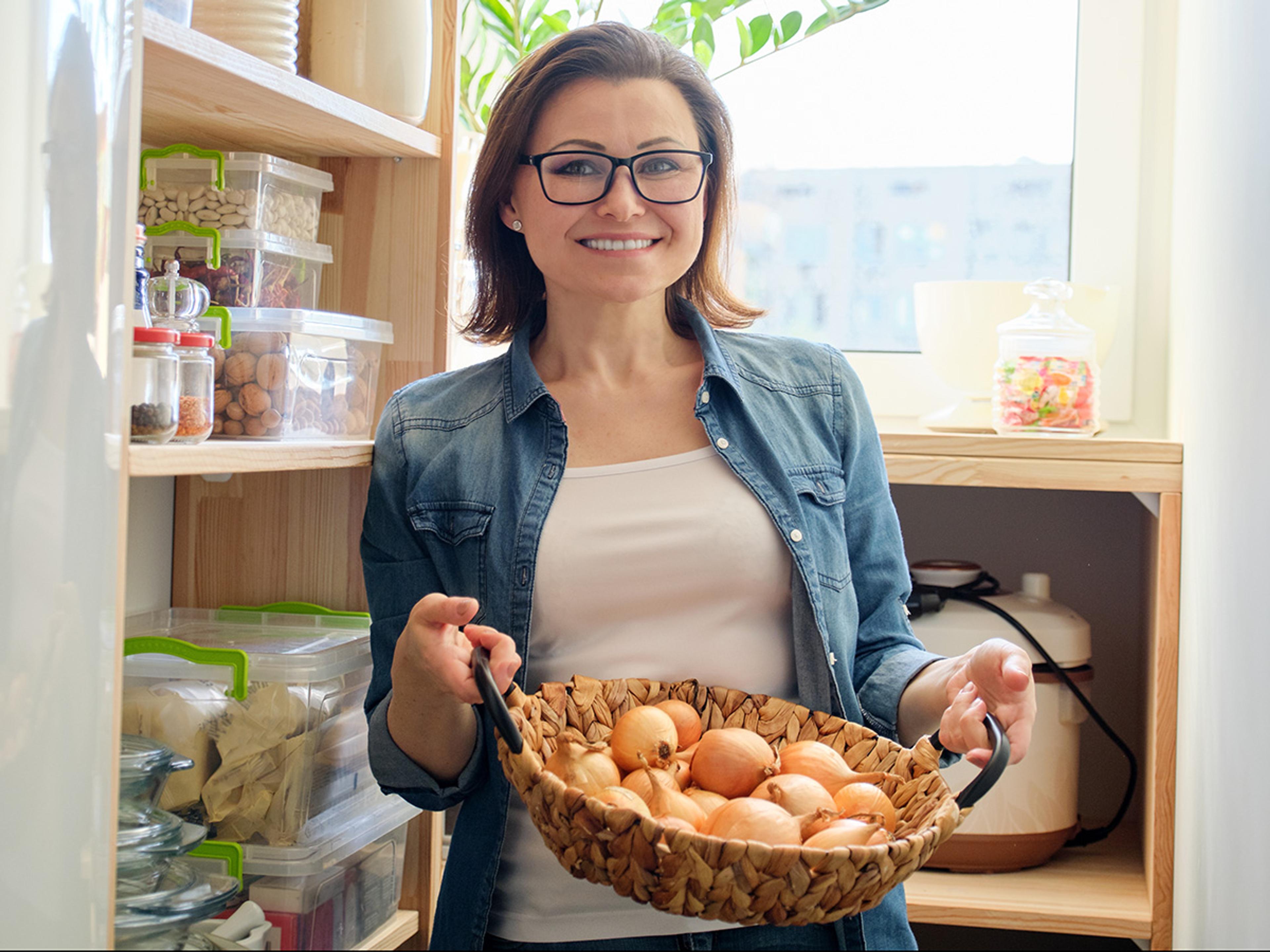 Women holds a basket of organic in her pantry.