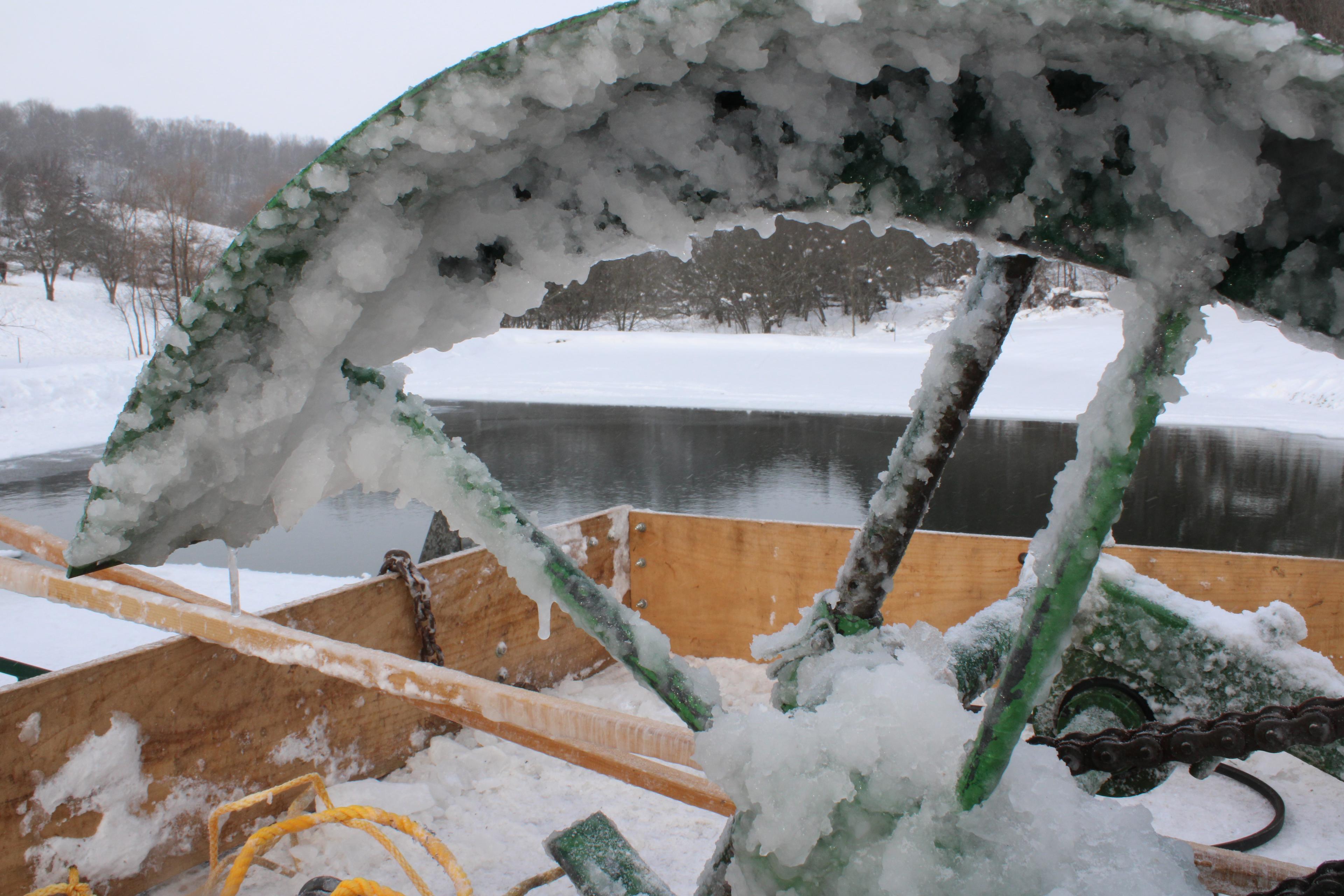 An ice saw covered with ice rests in the back of a wagon after hours of use.