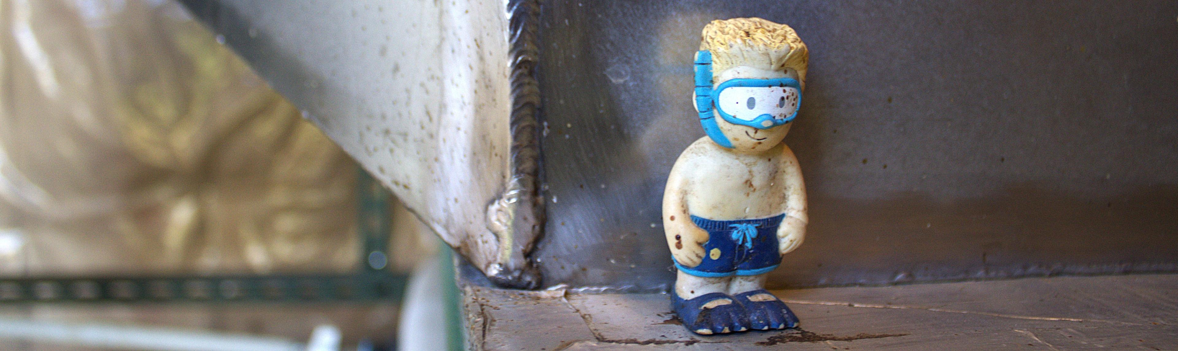A small plastic figurine in a scuba mask and swim trunks. 