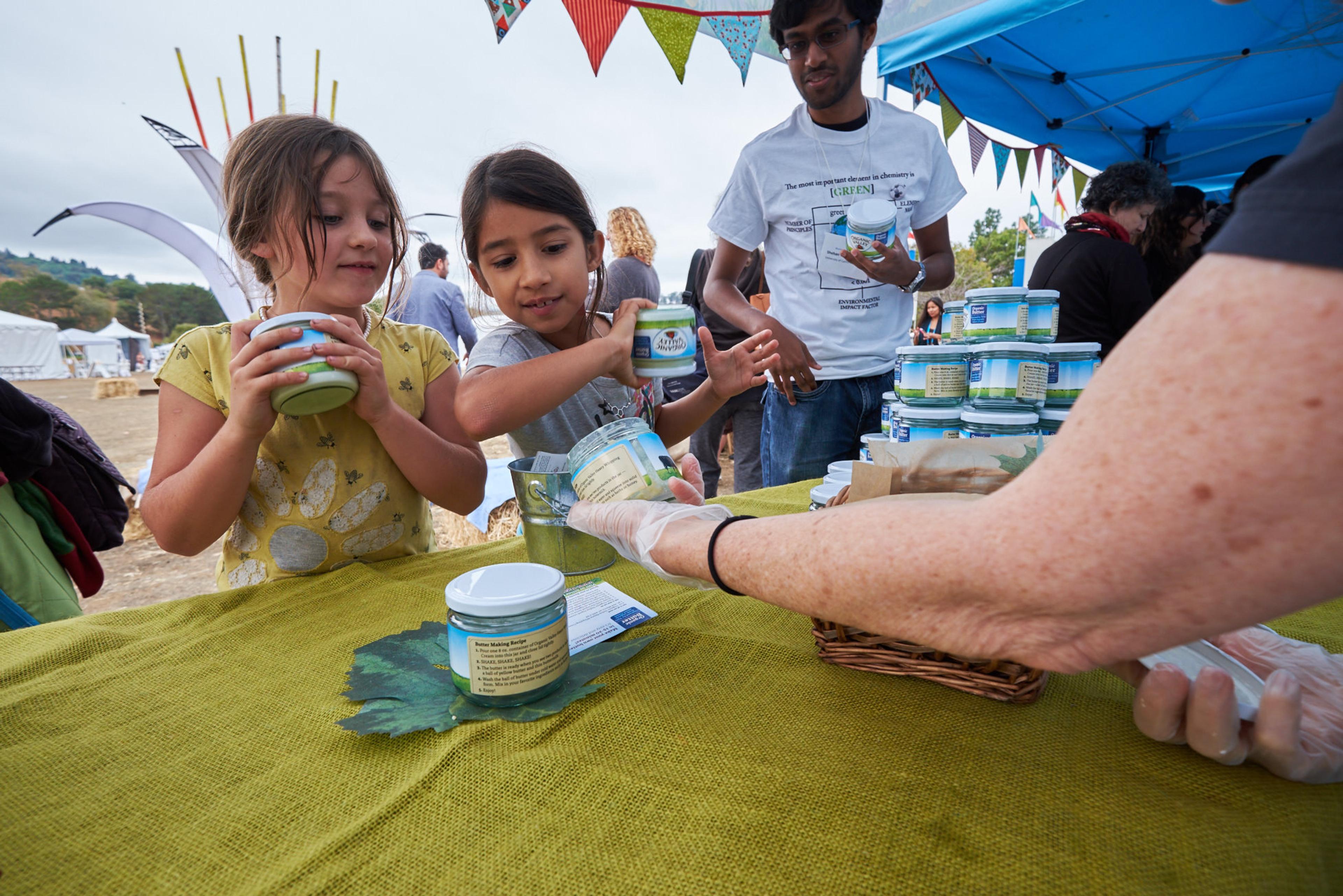 Kids shake up jars of butter from Organic Valley cream at an event.