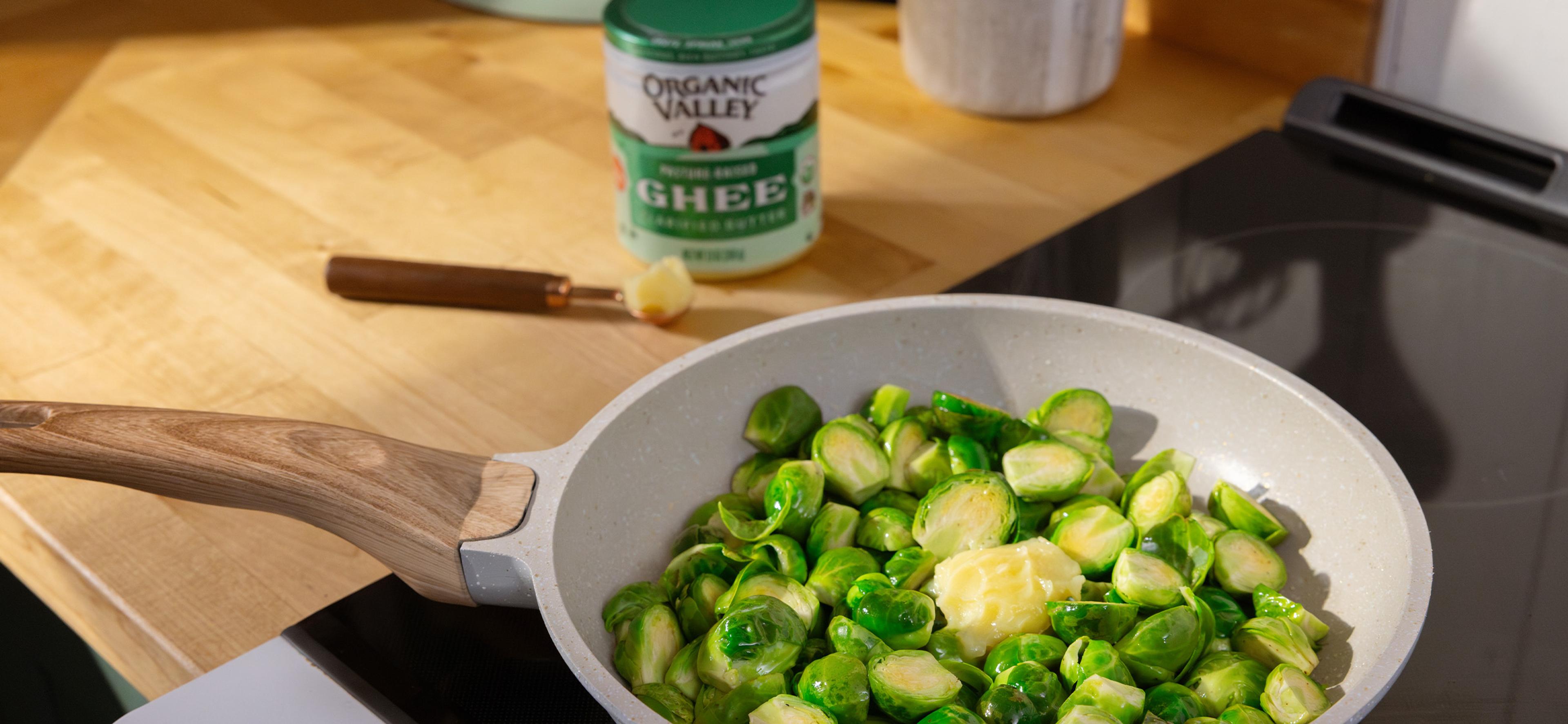 Ghee next to a pan of Brussel sprouts