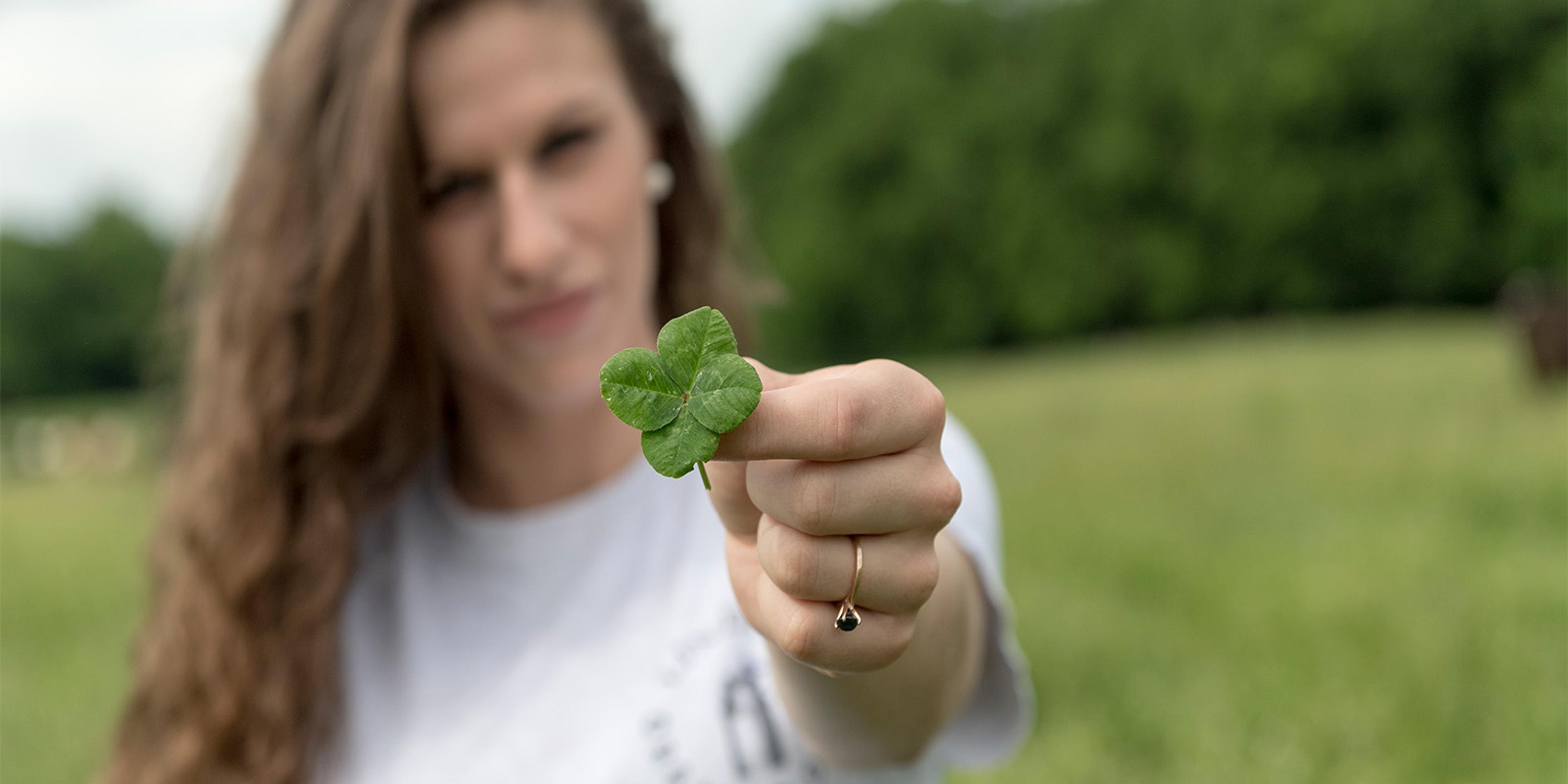 A woman holds a four-leaf clover on the Lindley’s organic dairy farm in North Carolina.