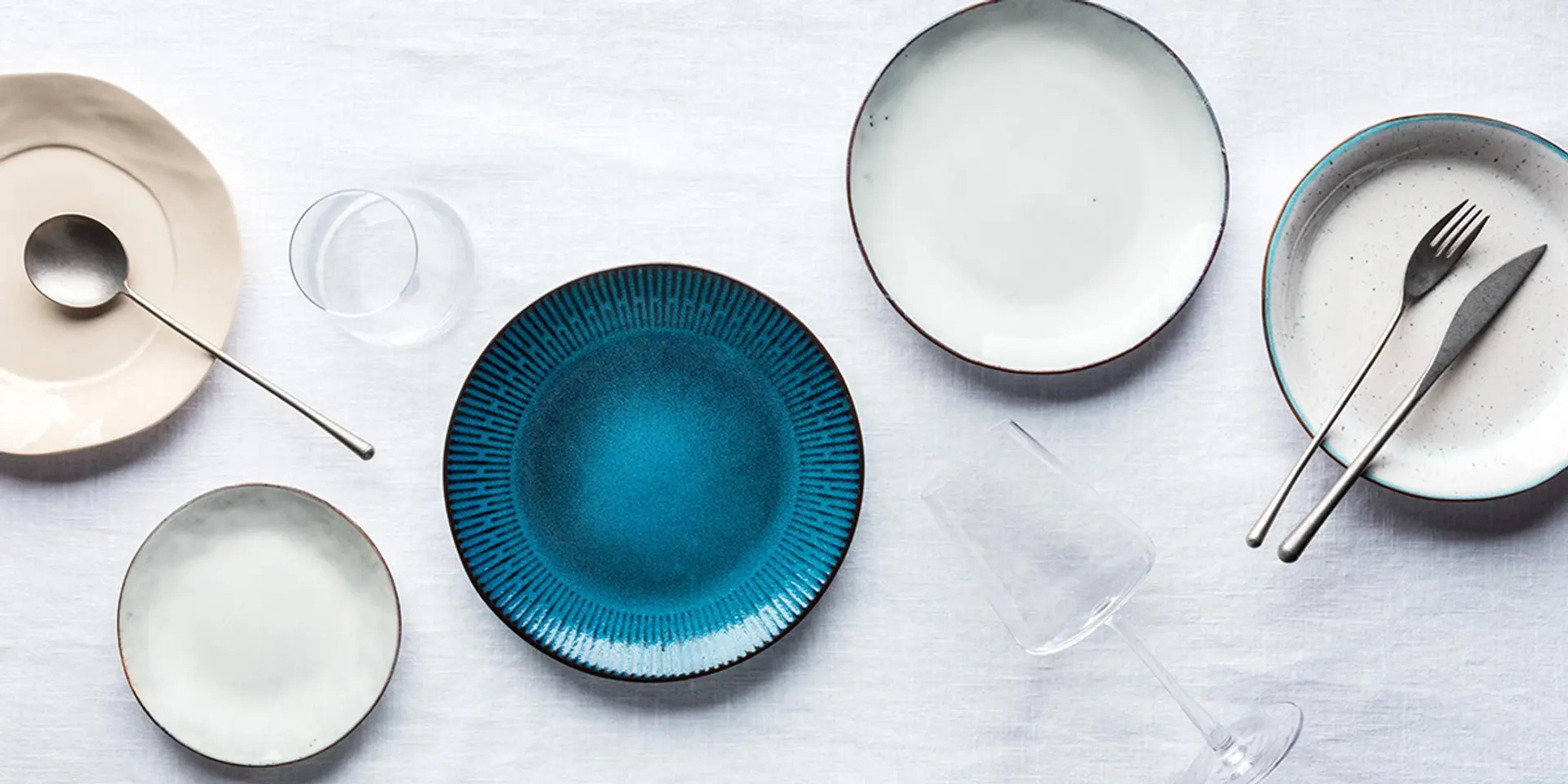 An assortment of plates, silverware, and cups.