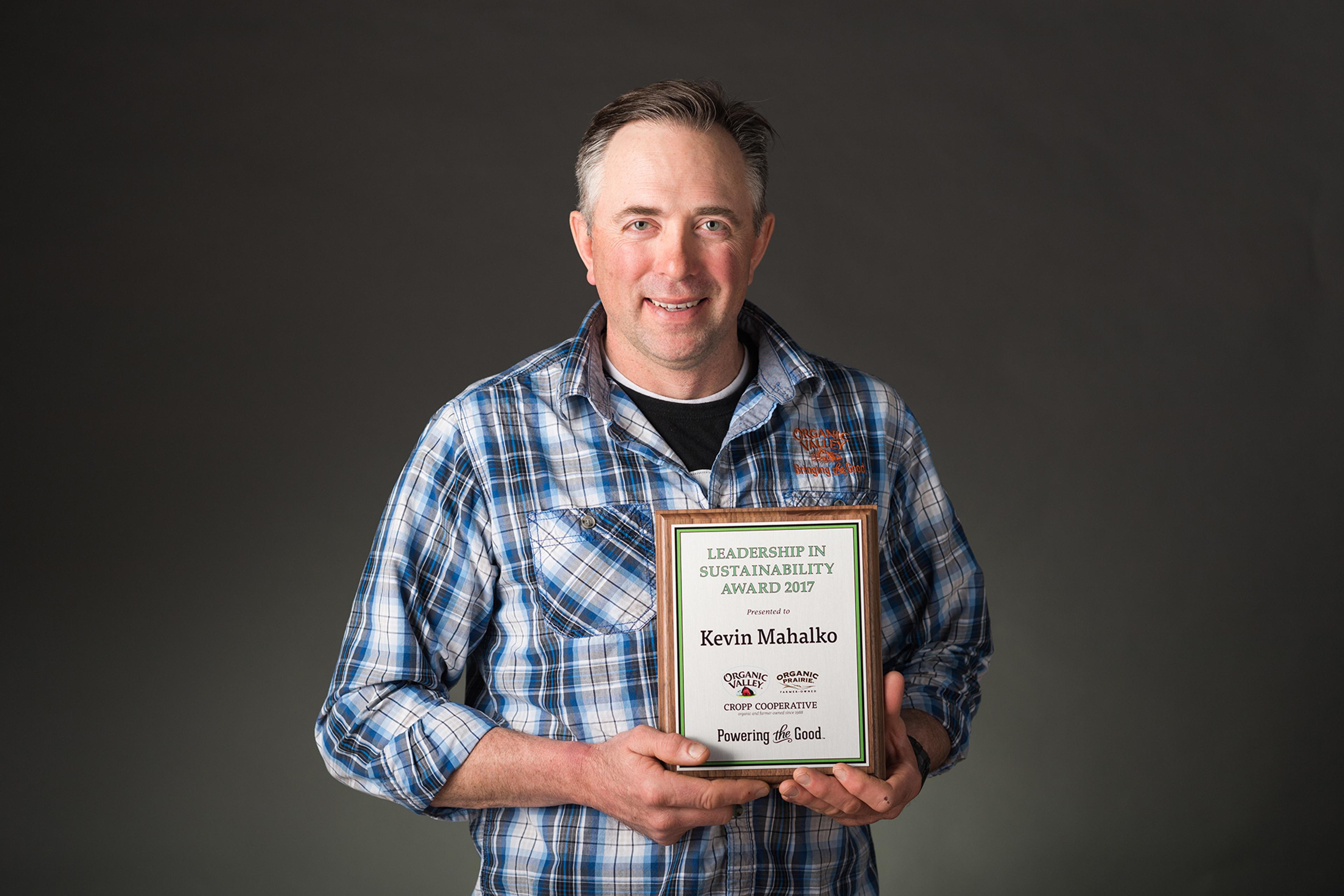 Kevin Mahalko holding an award for Leadership in Sustainability.