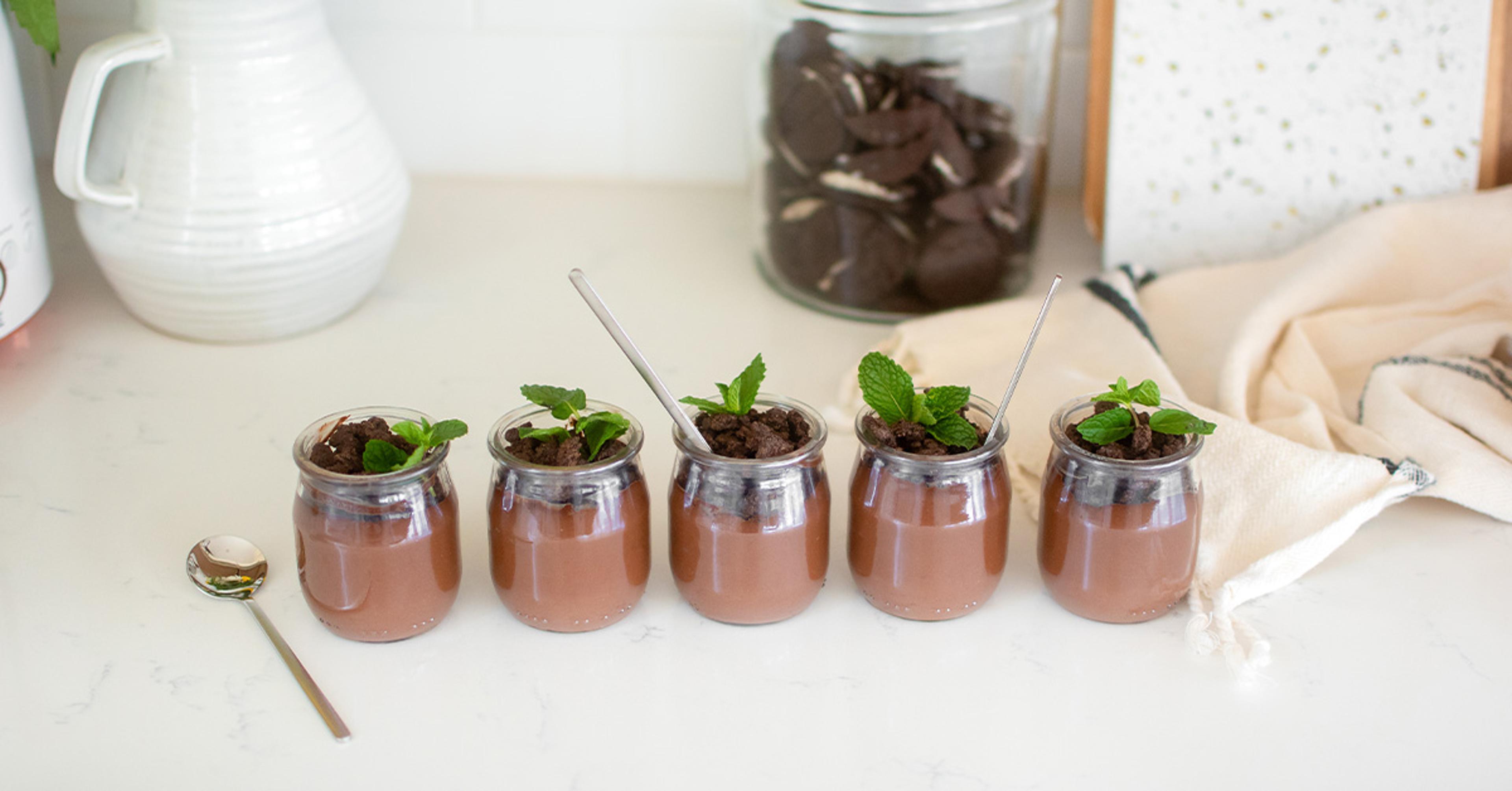 Five glass containers of mud pie on a counter.