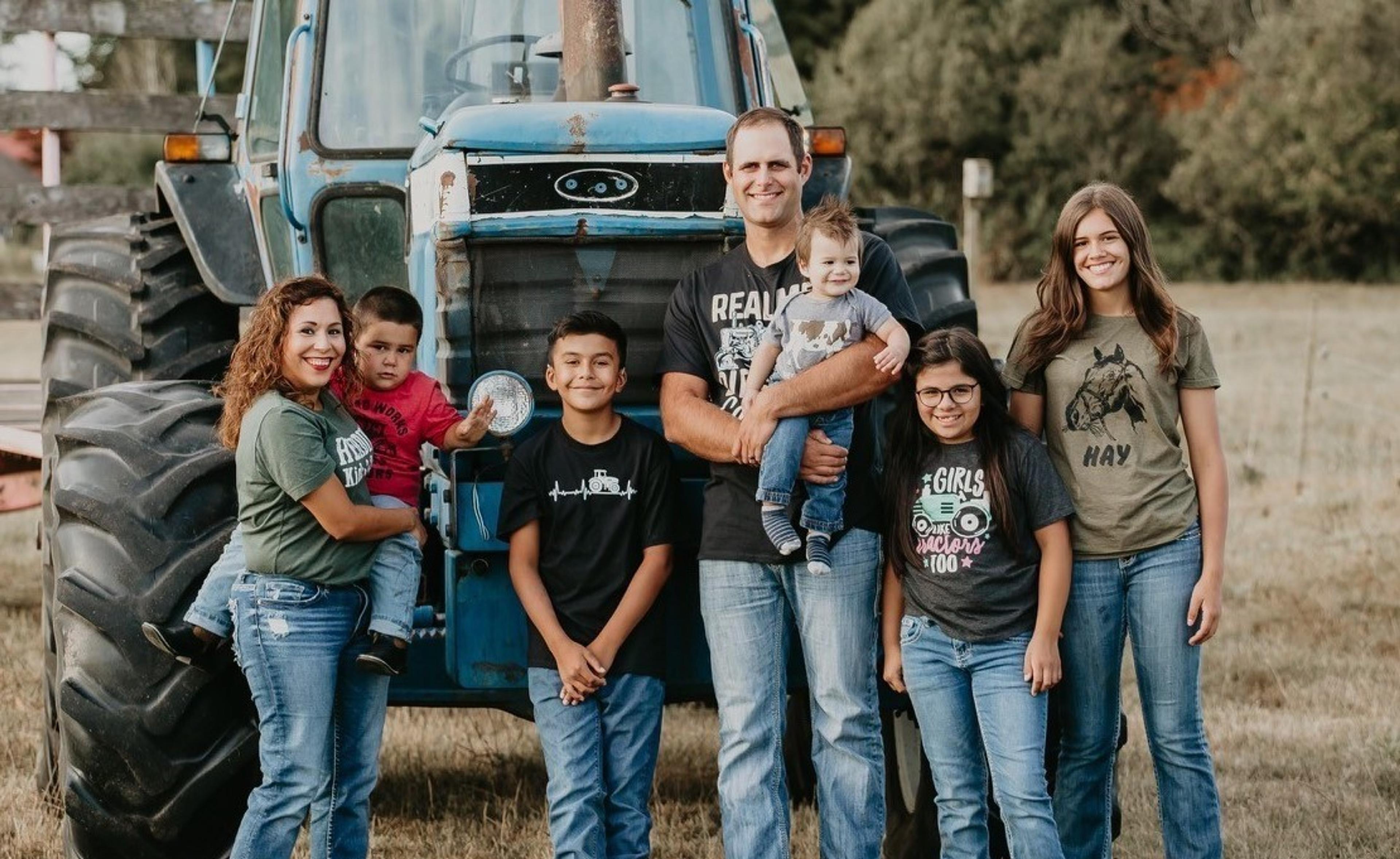 The Groen family poses in front of a tractor. Photo courtesy of Simona Nicolau Photography.